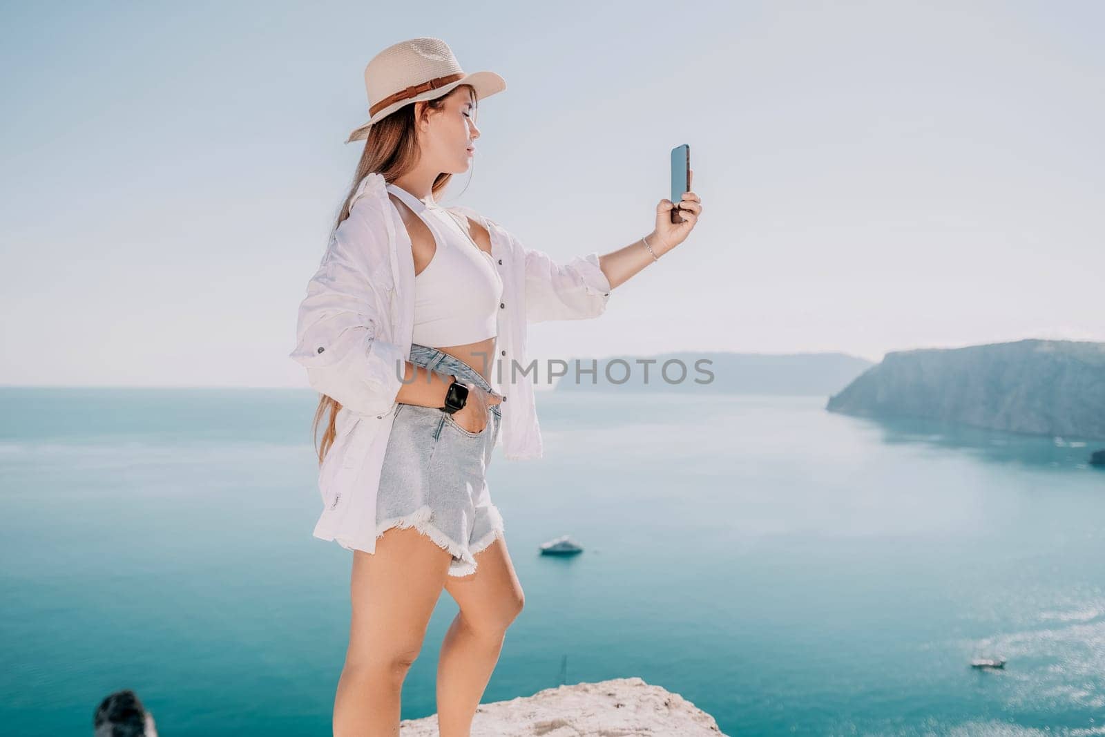 Woman sea laptop. Business woman in yellow hat freelancer with laptop working over blue sea beach. Girl relieves stress from work. Freelance, digital nomad, travel and holidays concept by panophotograph