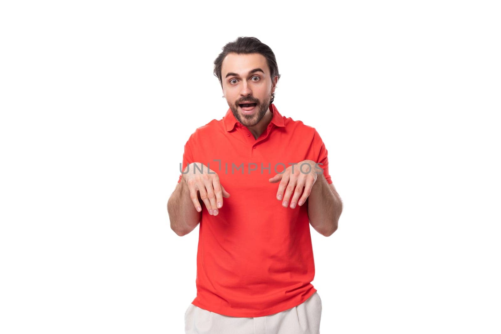young funny caucasian brunette man with beard dressed in casual red t-shirt on studio background with copy space.