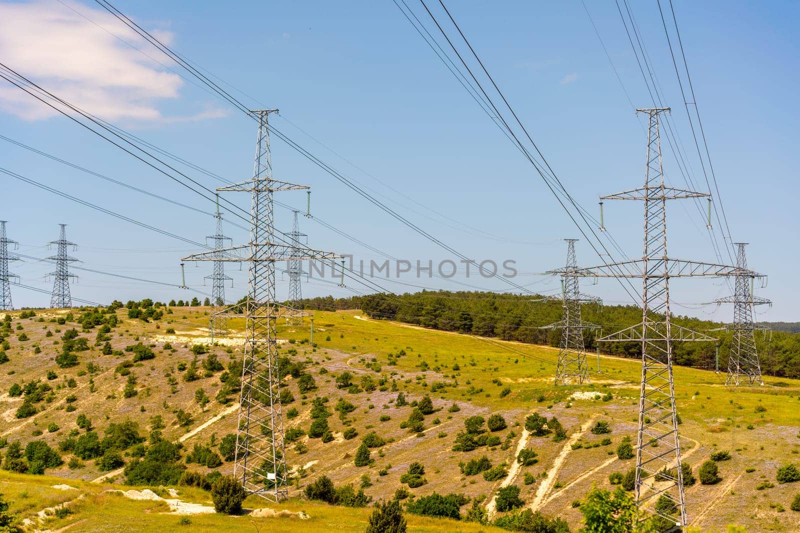 High voltage towers Electric pole. Power line support with wires for electricity transmission. High voltage grid tower with wire cable at distribution station. Energy industry, energy saving.