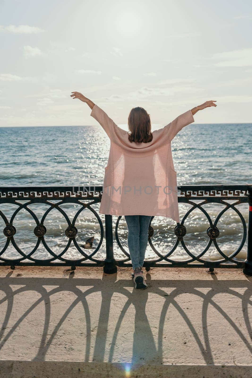 Woman summer travel sea. Happy tourist enjoy taking picture outdoors for memories. Carefree woman traveler posing on beach at sea on sunset, sharing travel adventure journey. Holiday vacation concept. by panophotograph