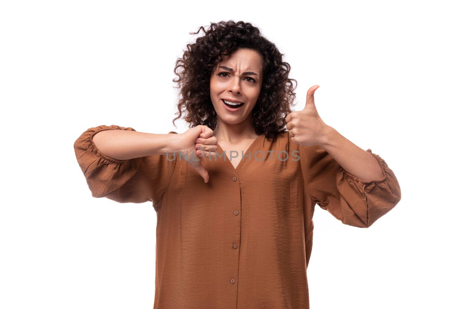 young curly businesswoman dressed in a brown blouse on a white background.