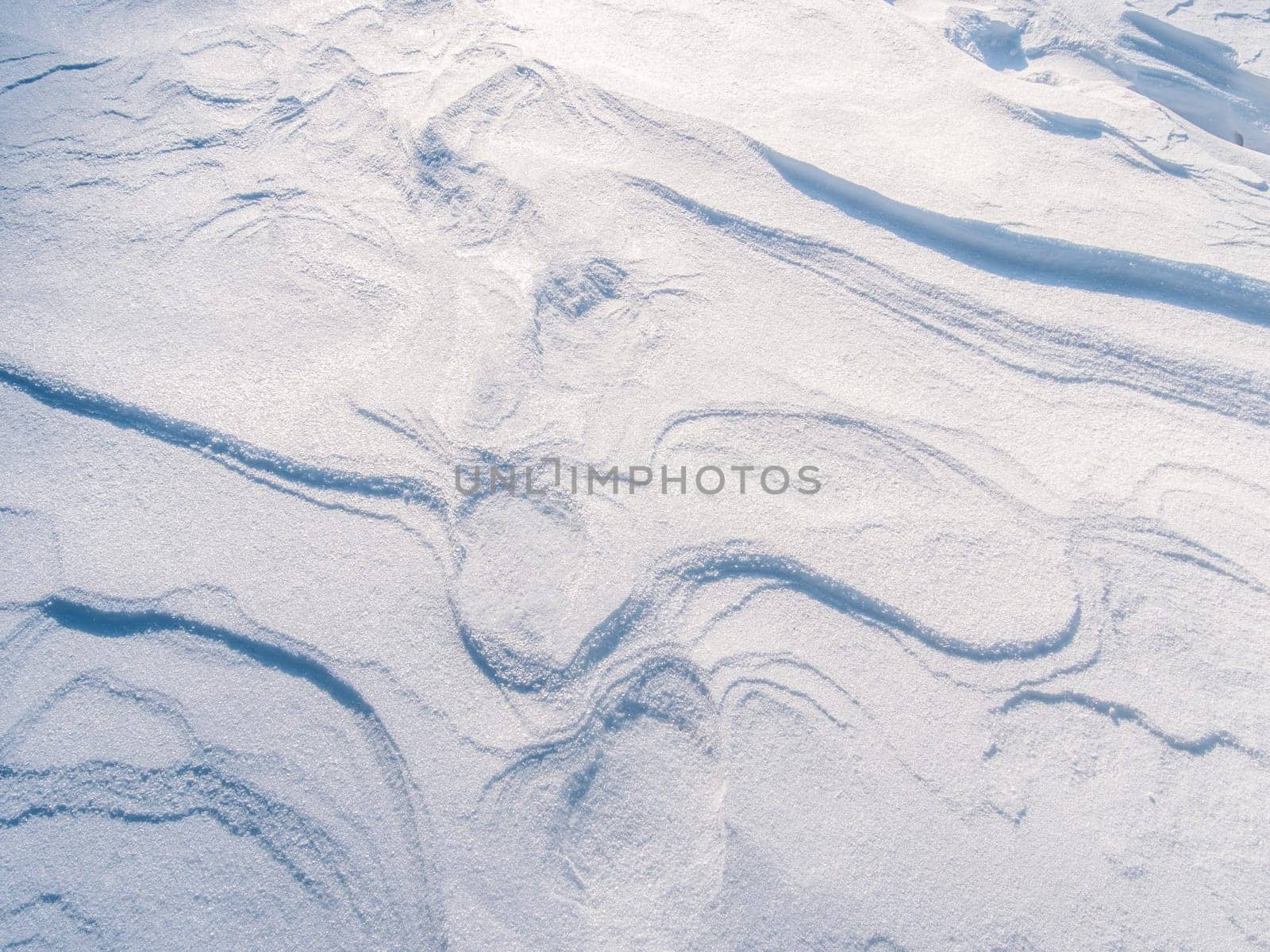 Snow texture with waves created by wind erosion.