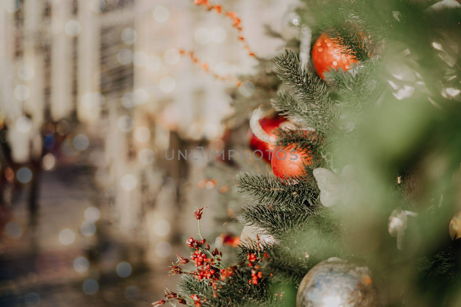 Close up of balls on christmas fir tree. Bokeh light garlands in background with copy space. Merry christmas and happy new year