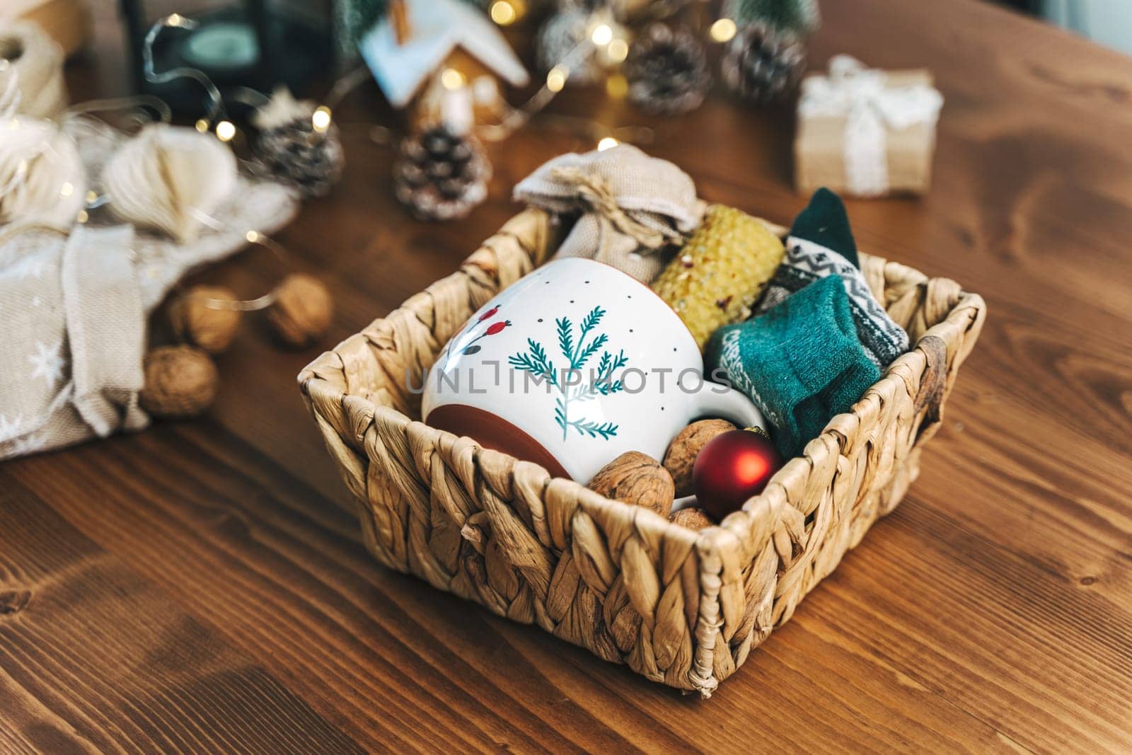 Christmas eco gift wicker basket, close up. Unprepared presents on wooden table with natural decor elements and items Christmas packing wrapping Concept.