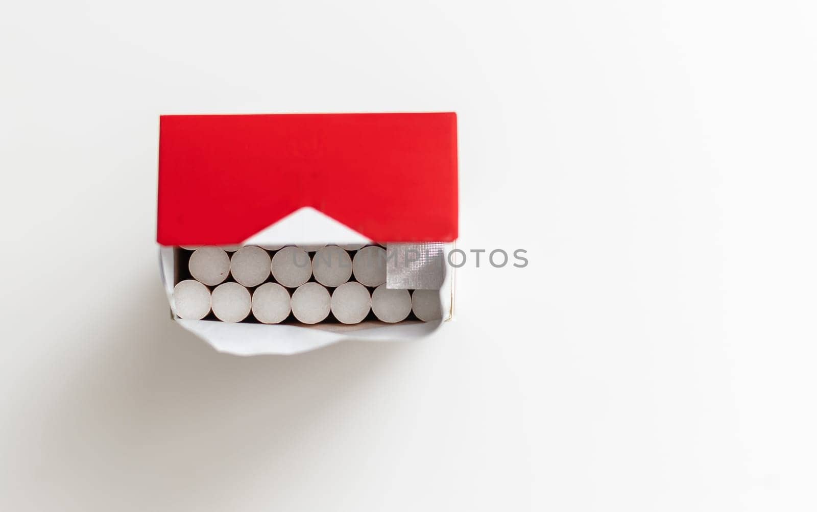 Cigarettes in an open red and white pack on a light table. High quality photo
