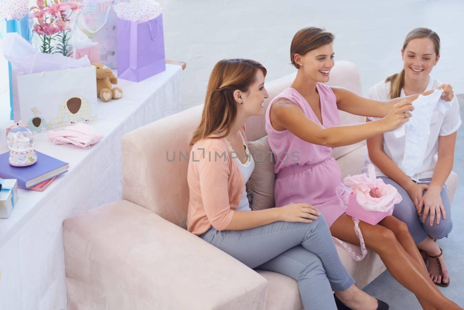 Women, baby shower and clothes in home, happy and grateful for support and present. Pregnant lady, smiling and excited for pregnancy, motherhood and celebrating child with best friends in house.