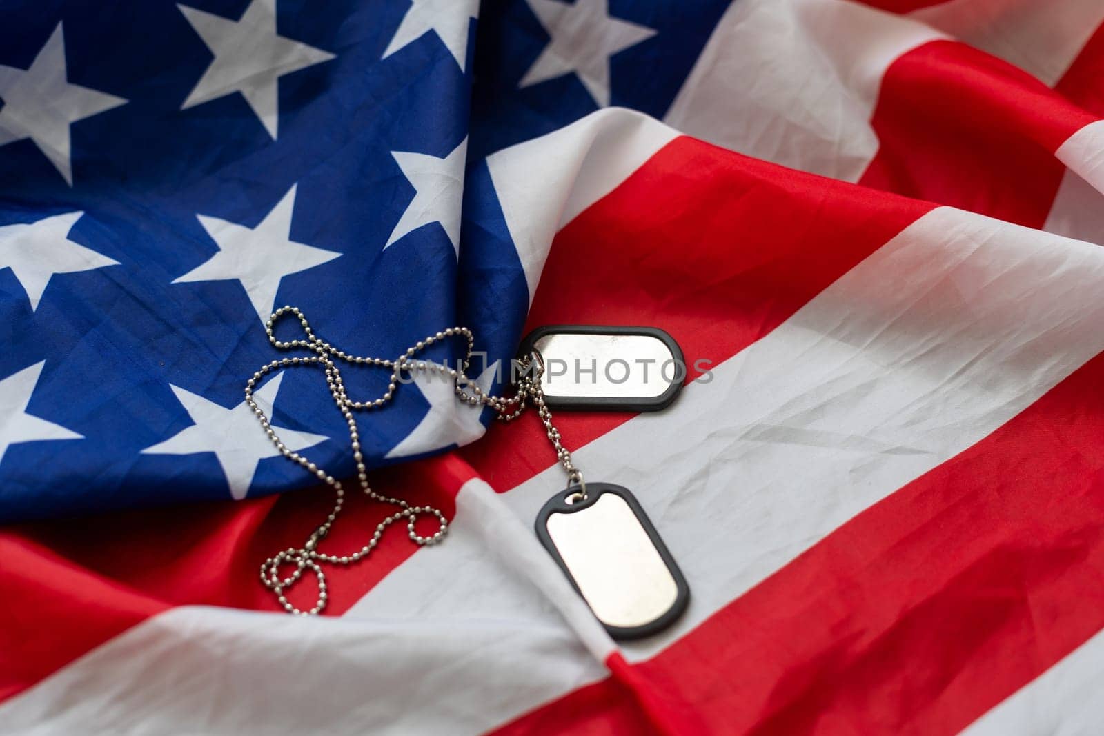 Dog tags and the flag of America. Focused on the dog tags. by Andelov13