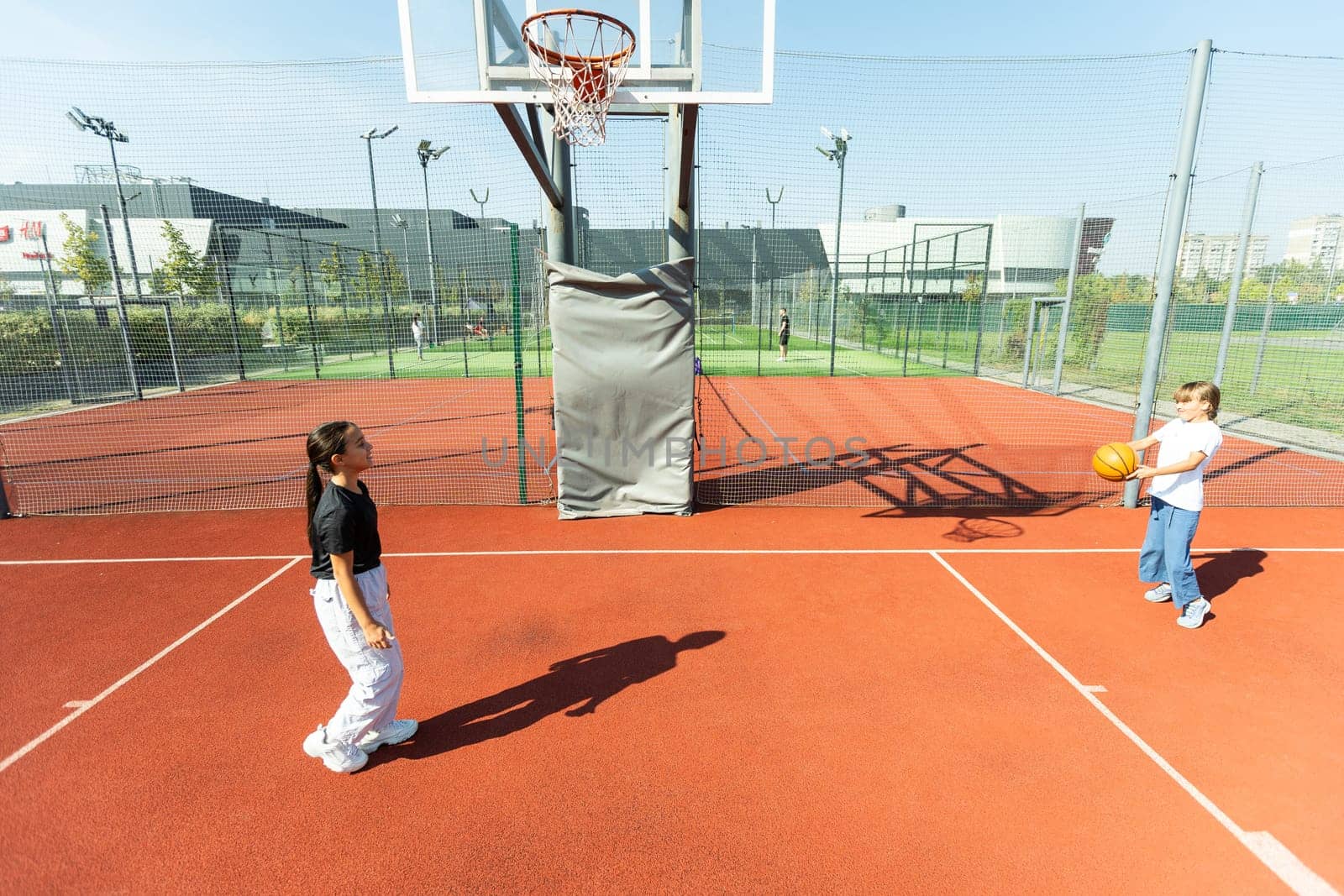 Children and sports. Teenage girl playing basketball on the playground. High quality photo