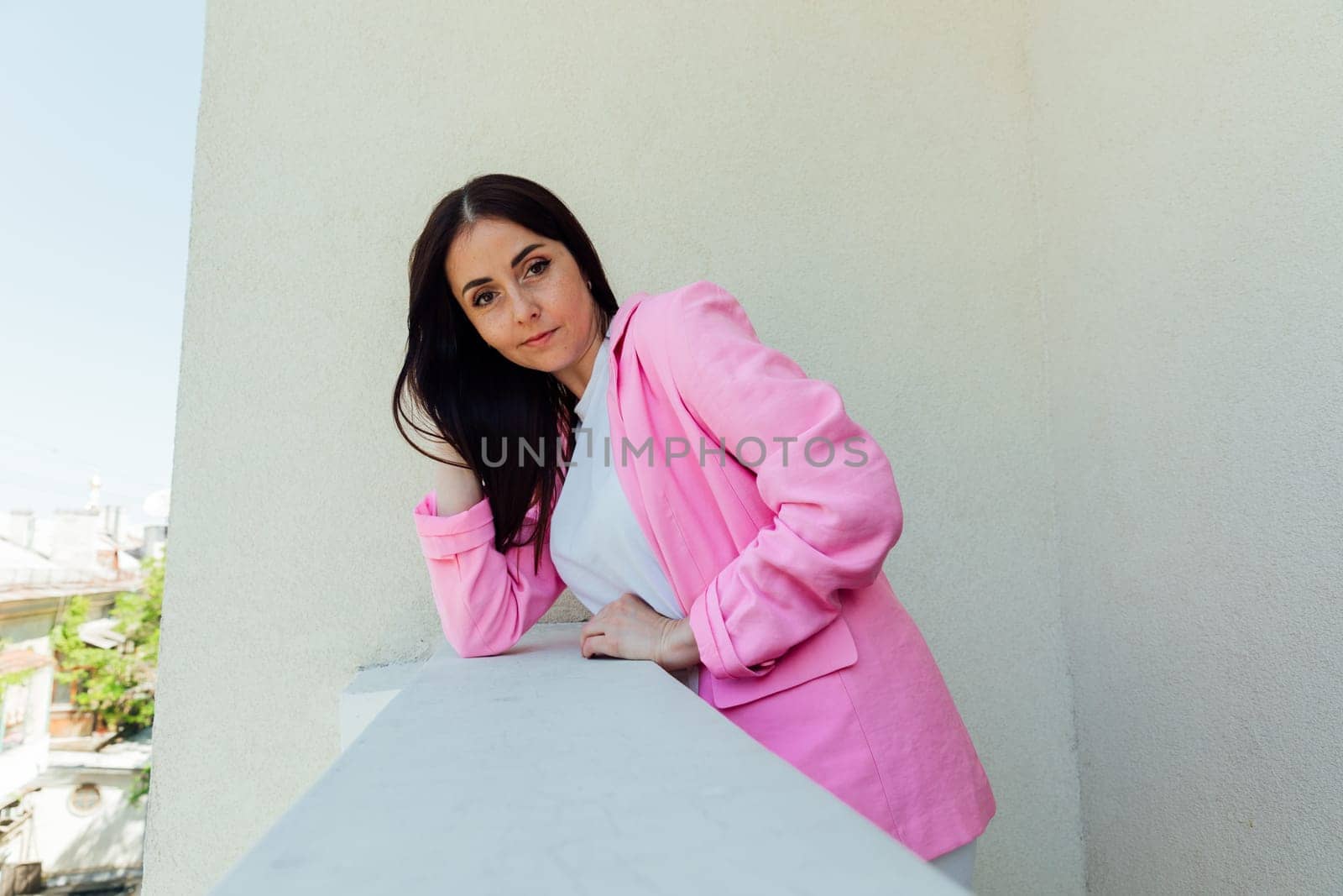 Portrait of a beautiful brunette woman in white clothes and pink jacket by Simakov