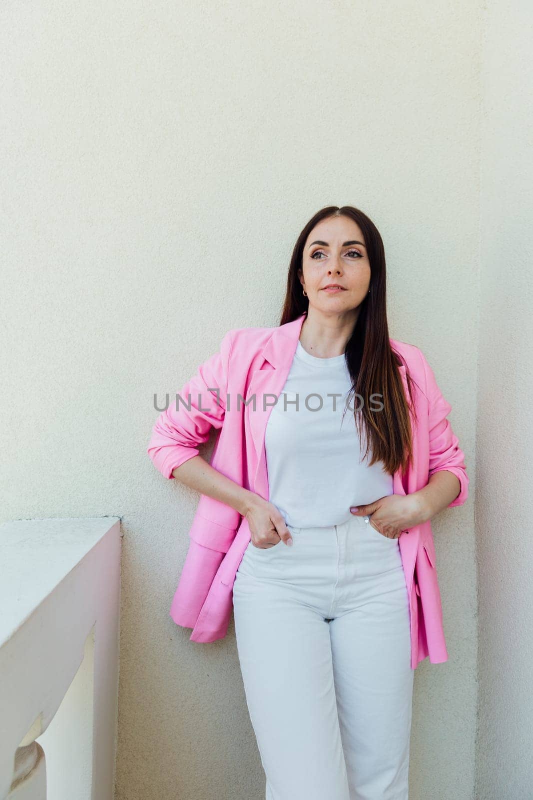 Portrait of a beautiful brunette woman in white clothes and pink jacket by Simakov