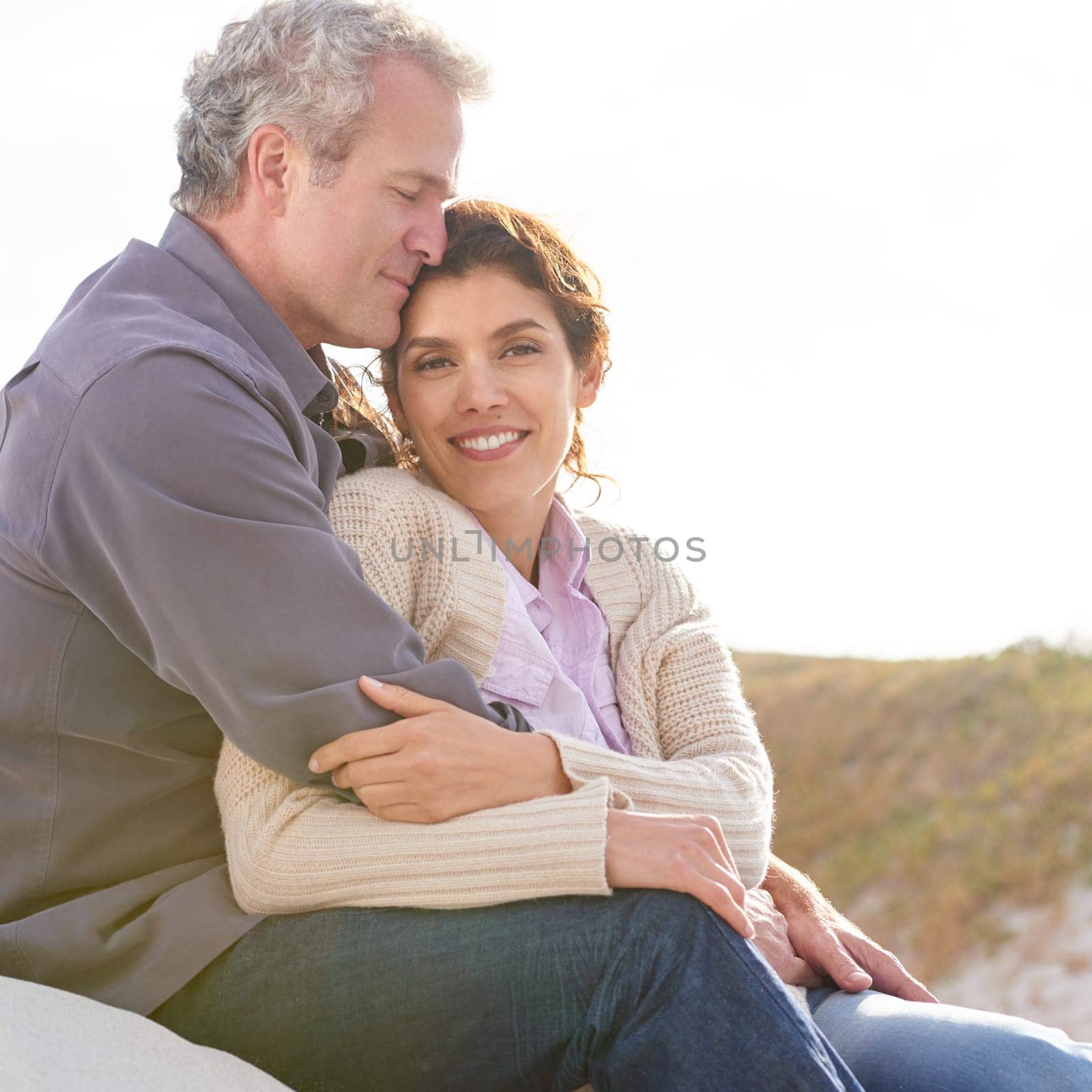 Couple, face and smile in nature with hug for romance, love and relationship outdoor with relaxing. Mature, man and woman or embrace with happy, peace and comfort for bonding, honeymoon and support.