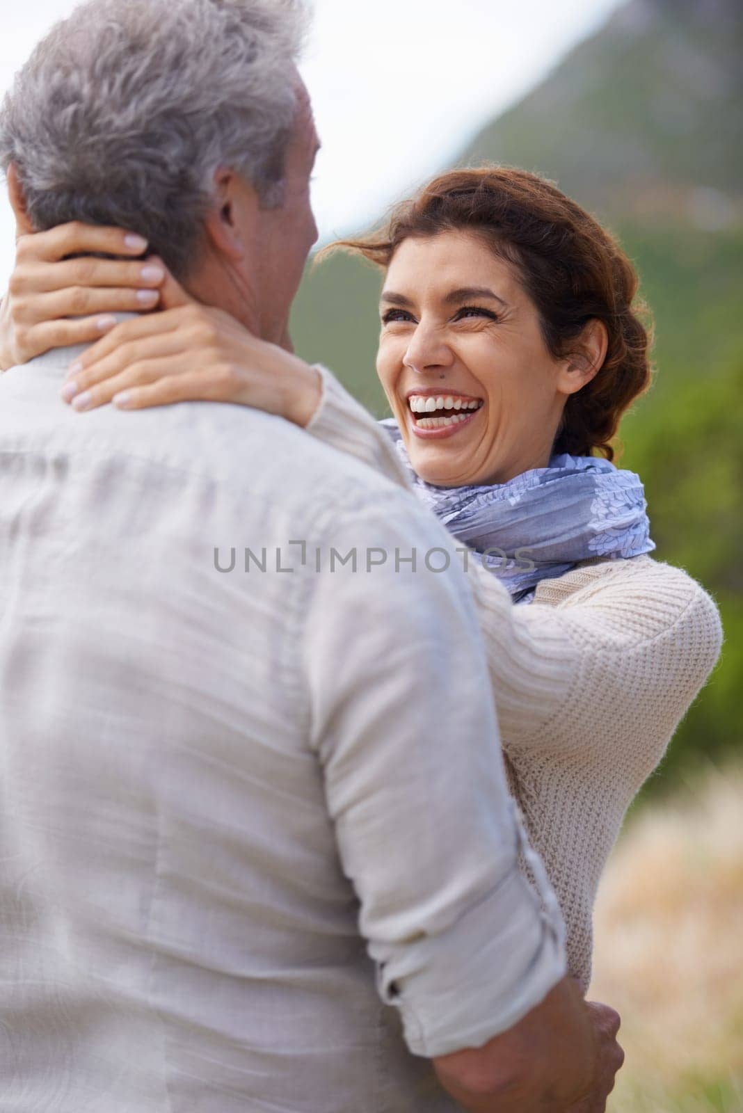 Couple, smile and hug in outdoors, travel and bonding or love, affection and security in relationship. Mature people, happy and laughing on vacation, holiday and adventure or getaway, embrace or care by YuriArcurs