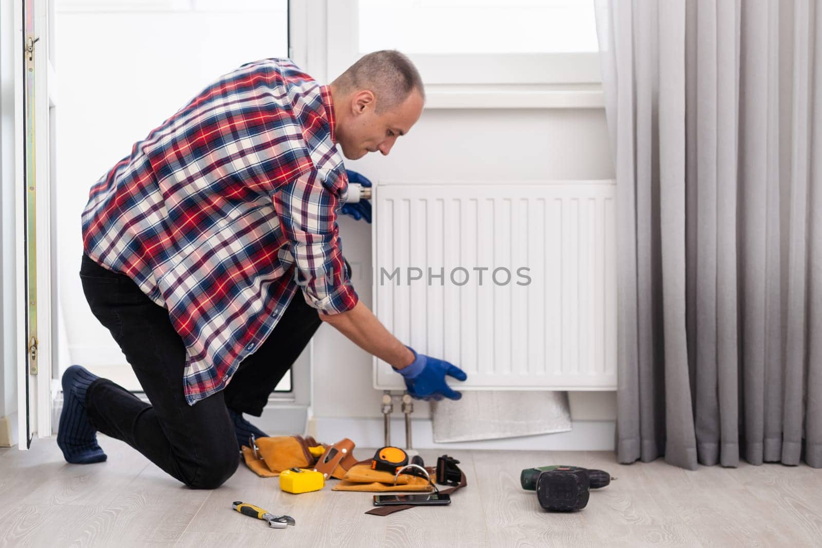 Repair heating radiator close-up. man repairing radiator with wrench. Removing air from the radiator. High quality photo