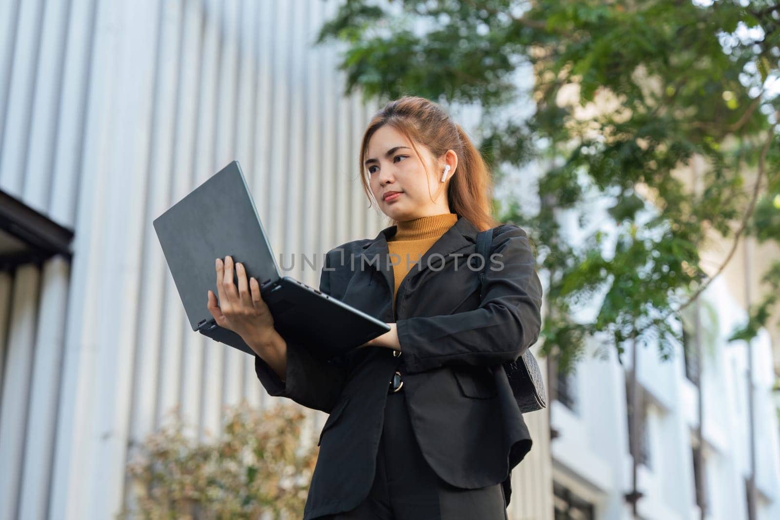 Business woman successful walking outdoors to work. beautiful woman going to working with laptop walking near office building.