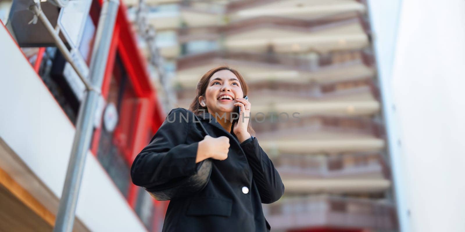 Business woman successful using smartphone walking outdoors to work. beautiful woman going to working with smartphone walking near office building by nateemee