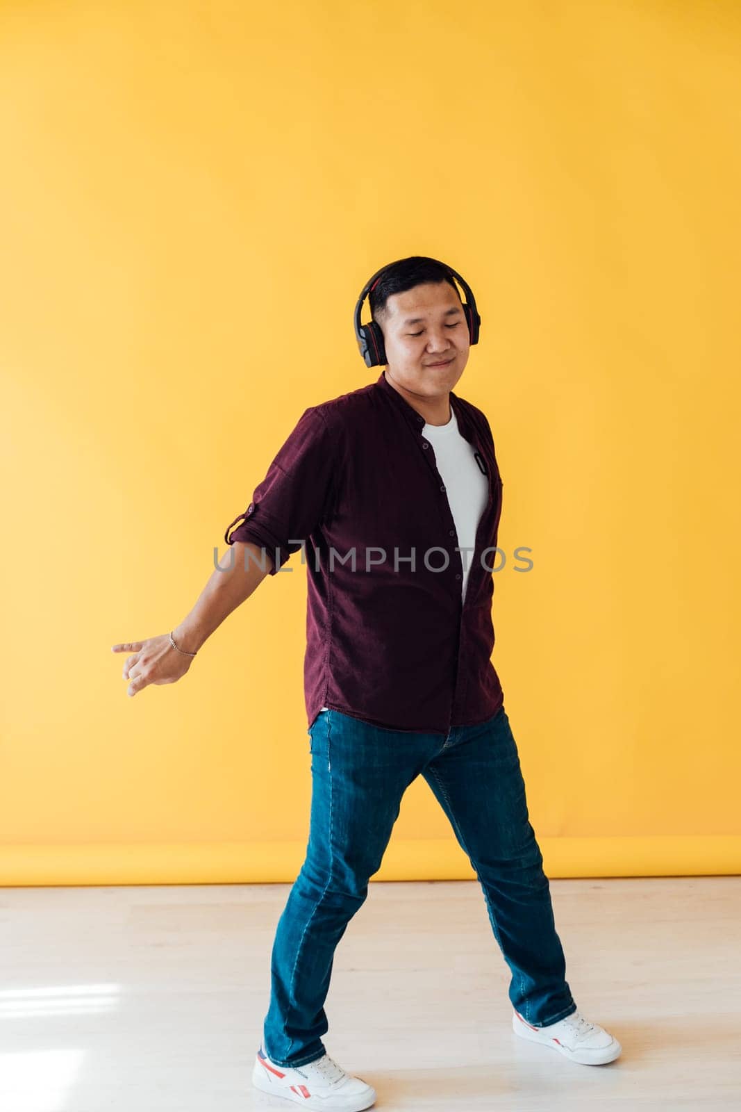 Enjoy The Rhytm. Cheerful American Guy In Wireless Headphones Listening Music And Dancing, by Simakov