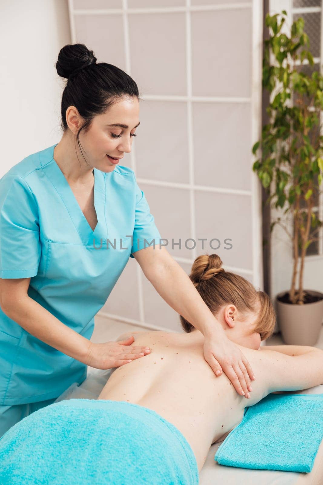 Masseuse doing a therapeutic relaxing back massage by Simakov