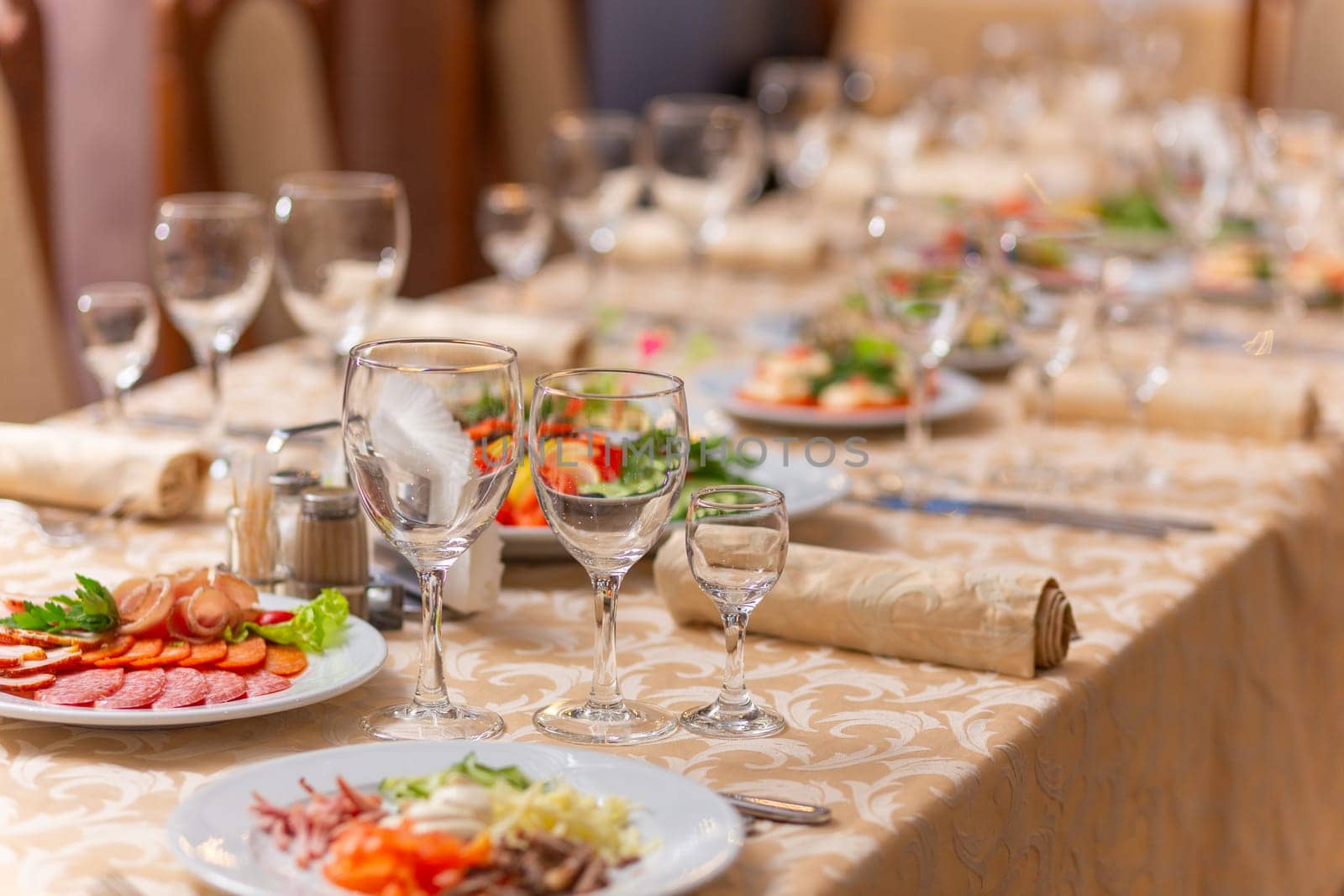 Served festive table with snacks, glasses, glasses, cutlery and napkins for a banquet on the occasion of a wedding or birthday or Christmas or other bright event in the restaurant