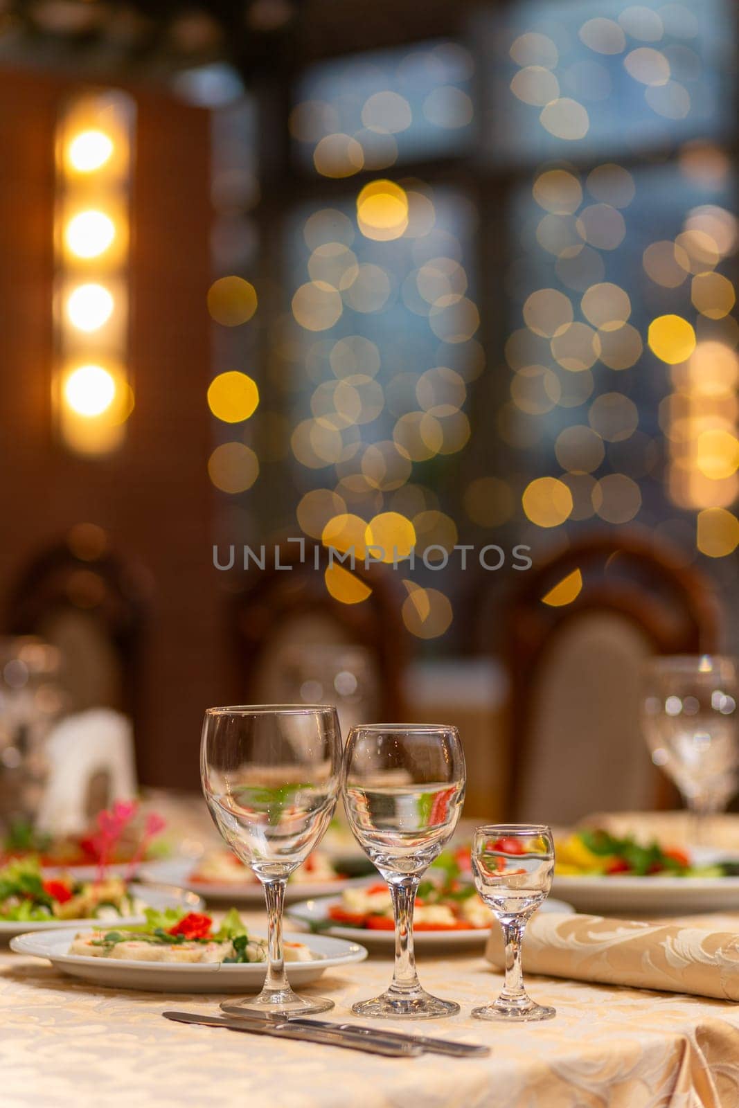 Served festive table with snacks, glasses, glasses, cutlery and napkins for a banquet on the occasion of a wedding or birthday or Christmas or other bright event in the restaurant