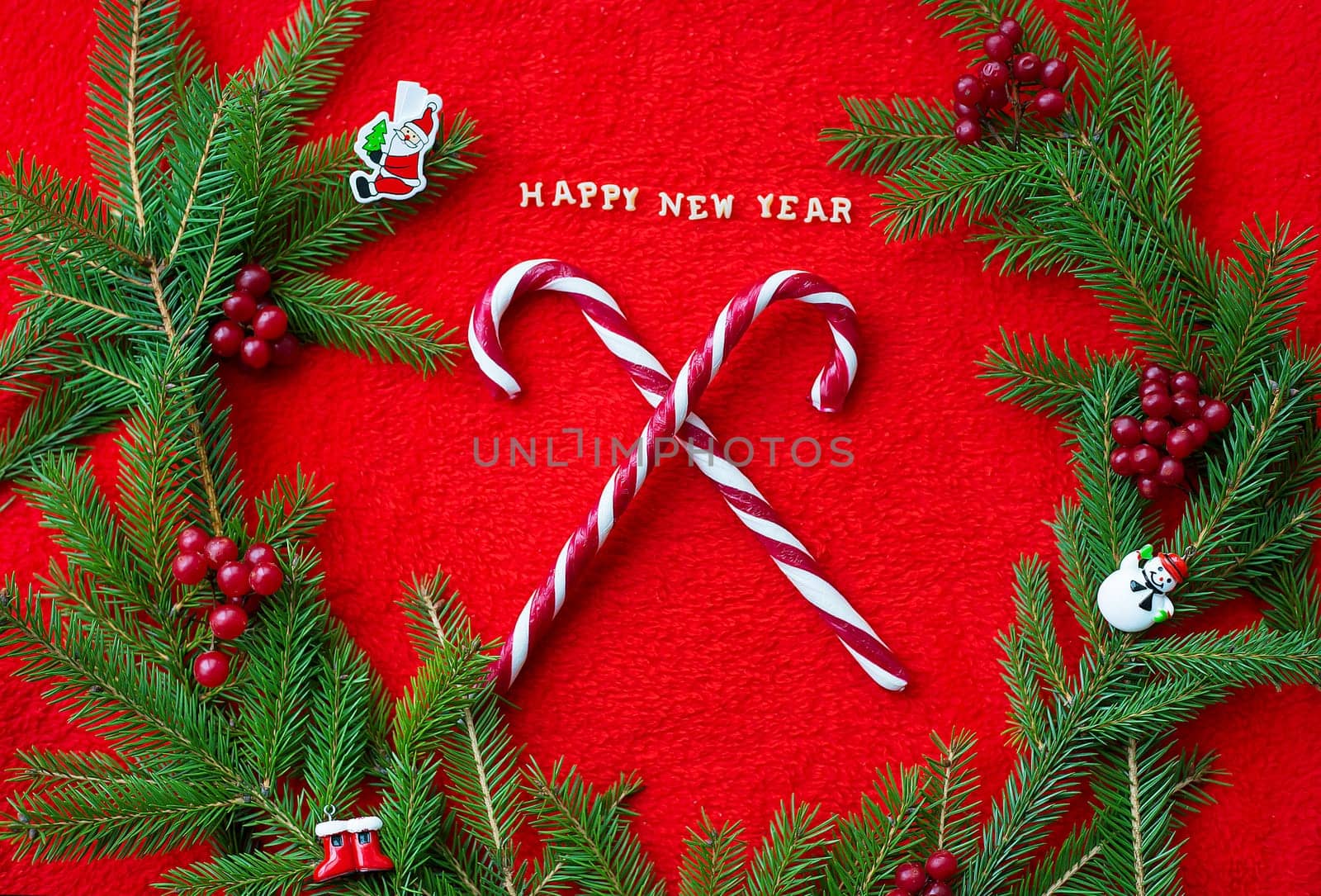 Christmas tree and candy on a red background with the words Happy New Year. Closeup