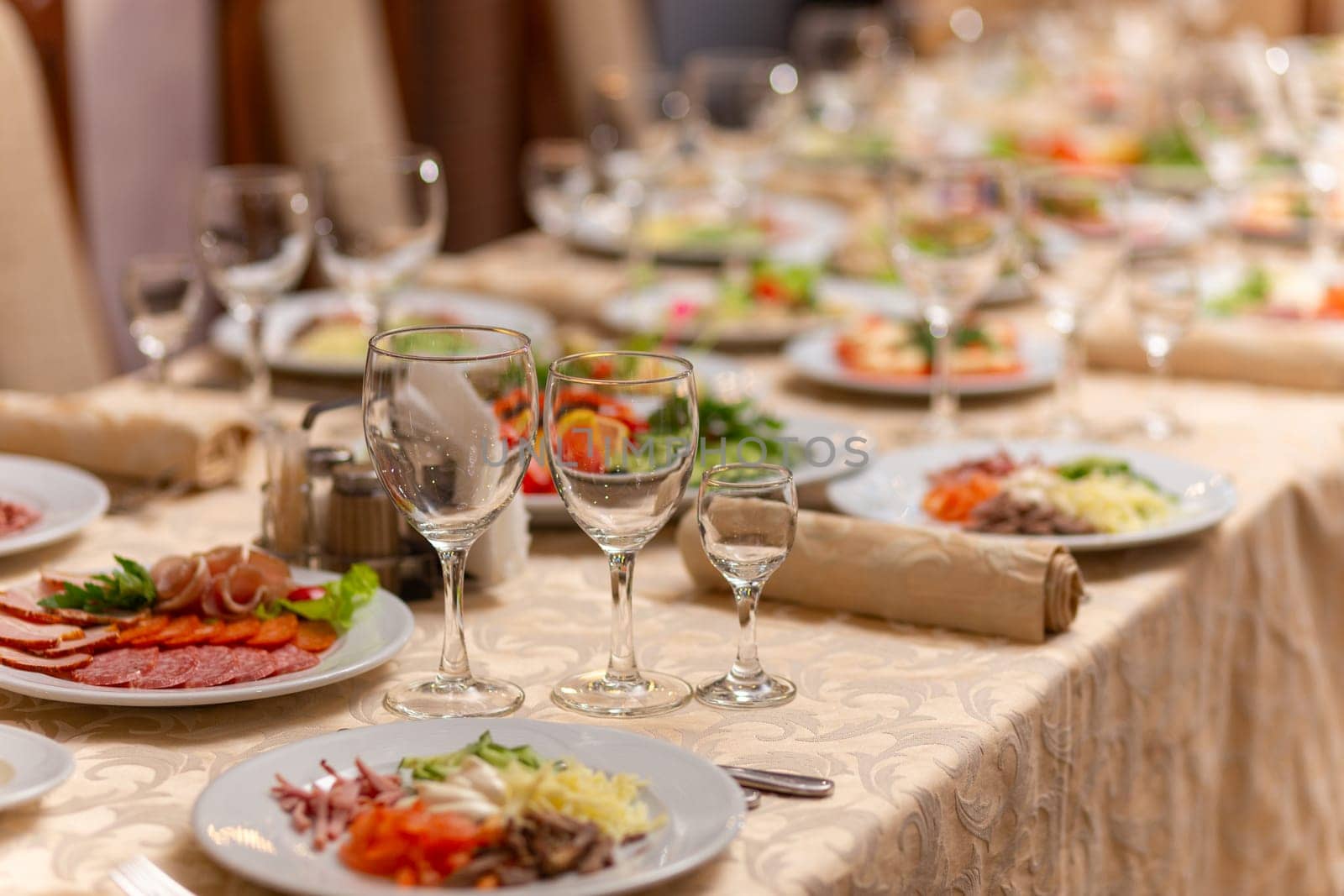 Served festive table with snacks, glasses, glasses, cutlery and napkins for a banquet on the occasion of a wedding or birthday or Christmas or other bright event in the restaurant