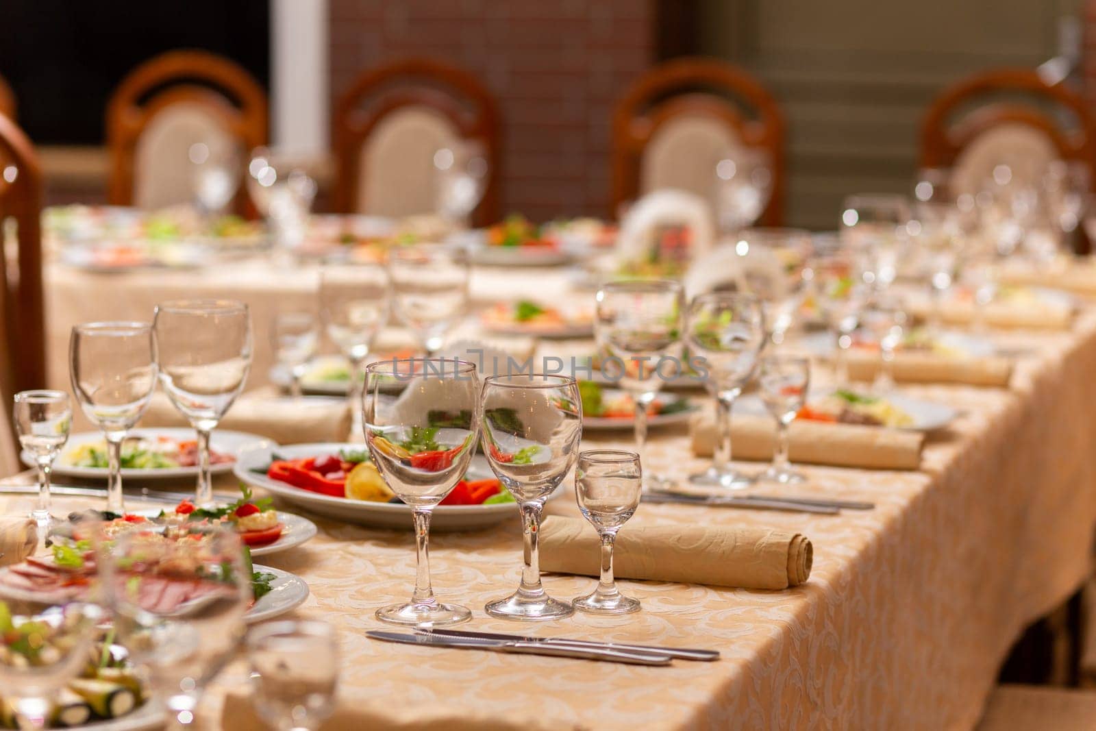 Served festive table with snacks, glasses, glasses, cutlery and napkins for a banquet on the occasion of a wedding or birthday or Christmas or other bright event in the restaurant