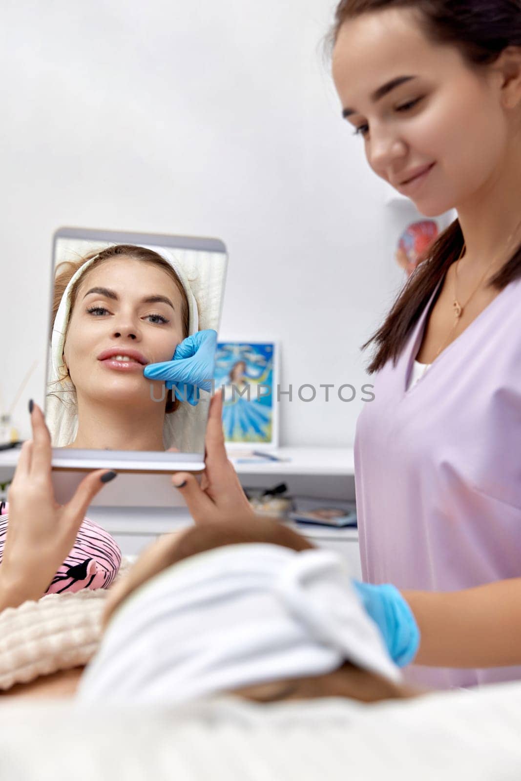 woman looks at mirror after procedure lip augmentation by erstudio