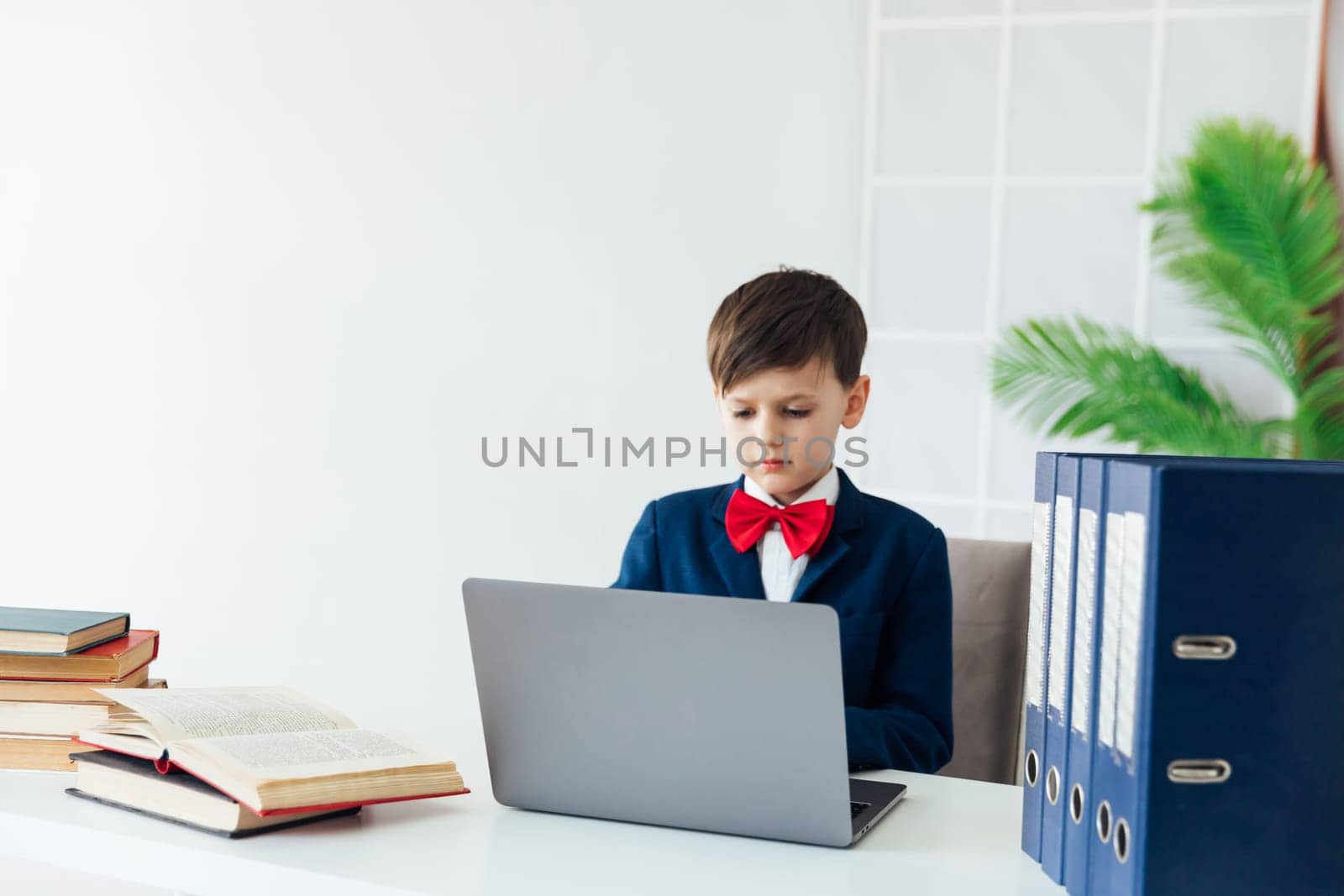 Little boy using laptop on white background by Simakov