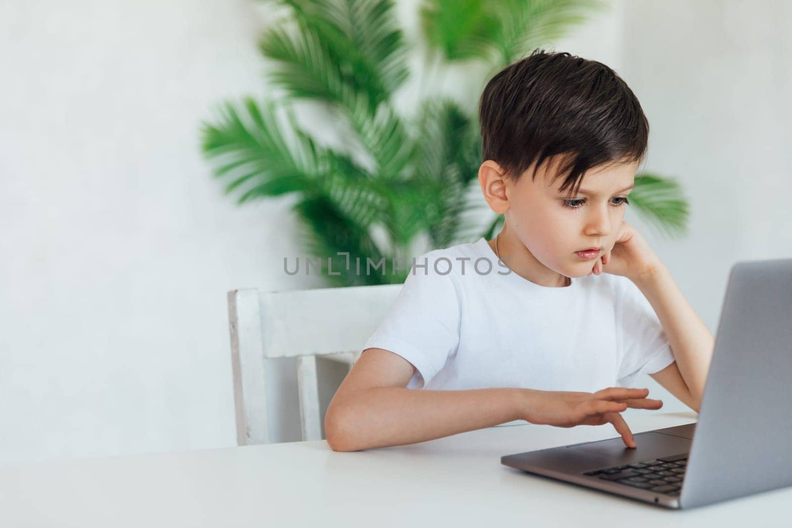 Little boy using laptop on white background