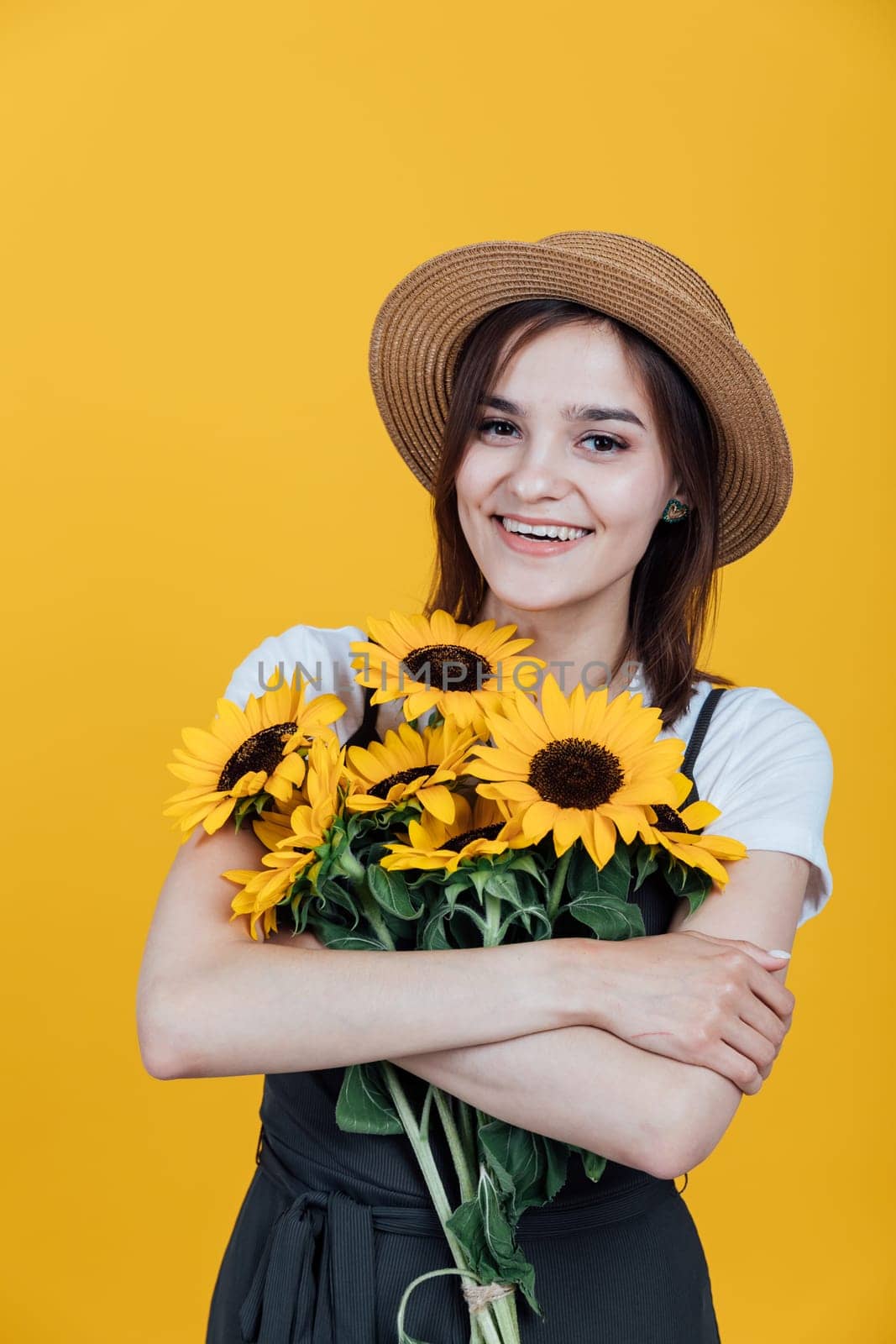 Portrait of a beautiful young woman with sunflower flowers on a yellow background by Simakov
