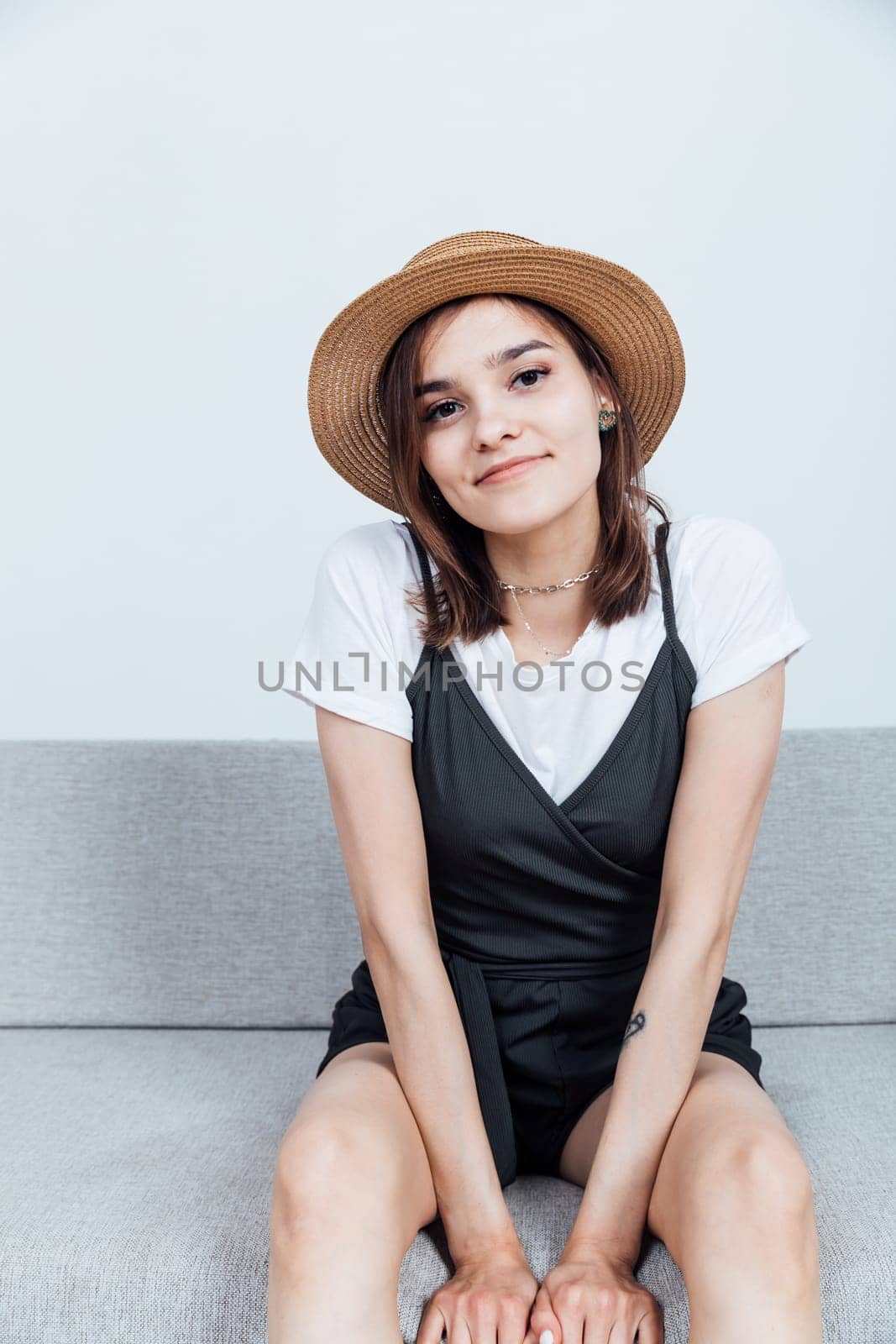 Portrait of a beautiful young woman in a black dress and hat by Simakov