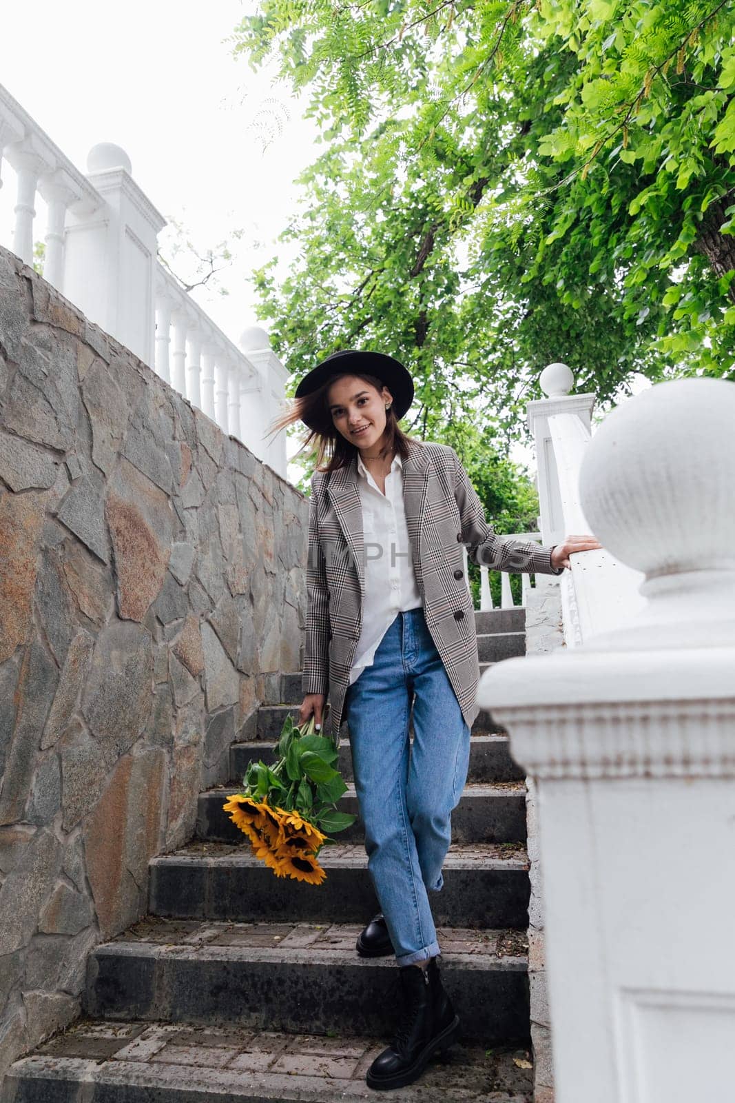 Beautiful young brunette woman in hat walking in autumn city