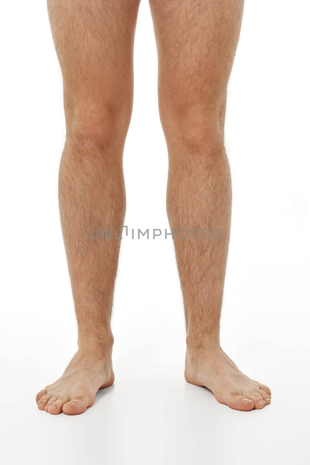 Barefoot male legs on white background. Body care concept.