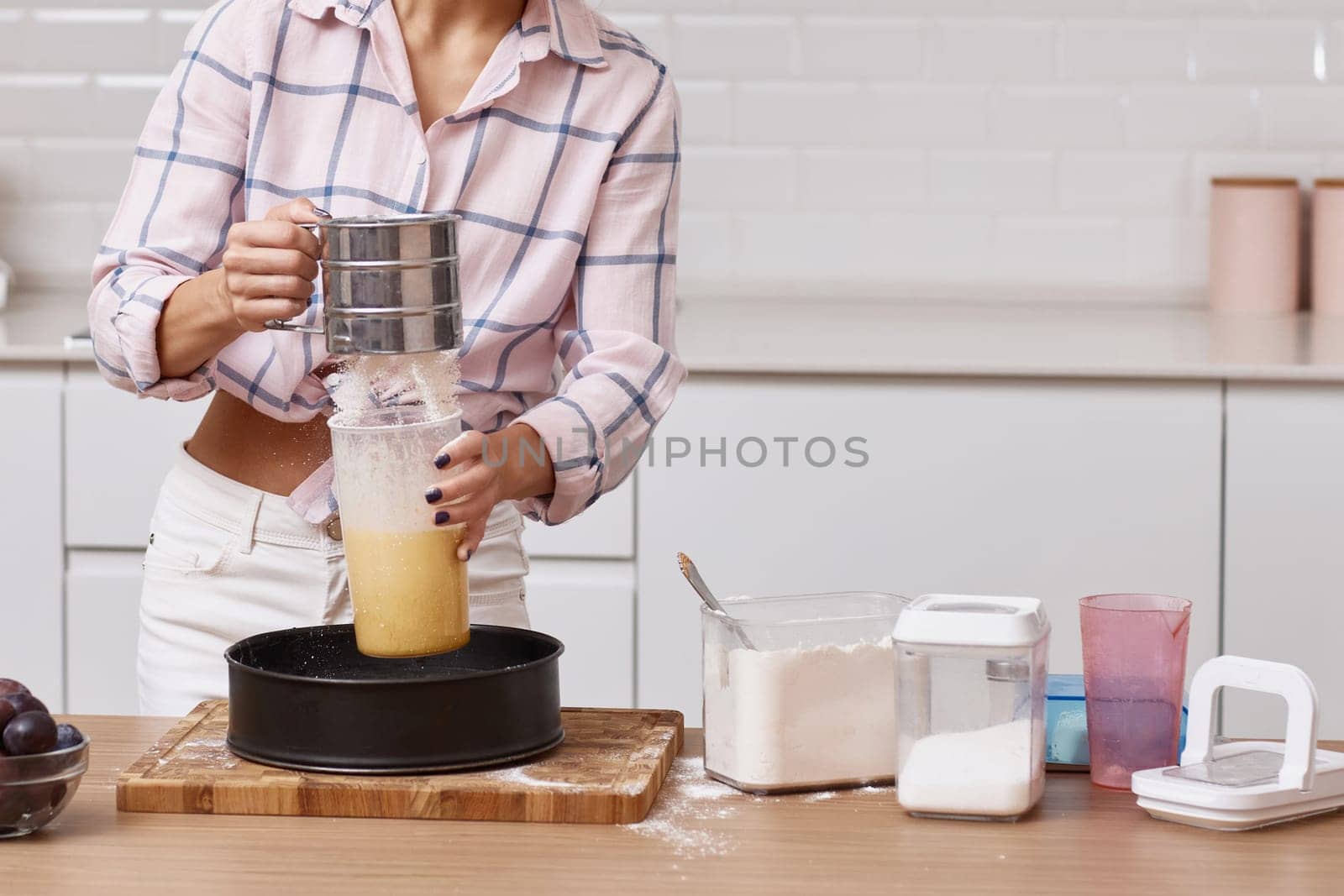 housewife woman sifting flour, female hands preparing pie in modern kitchen