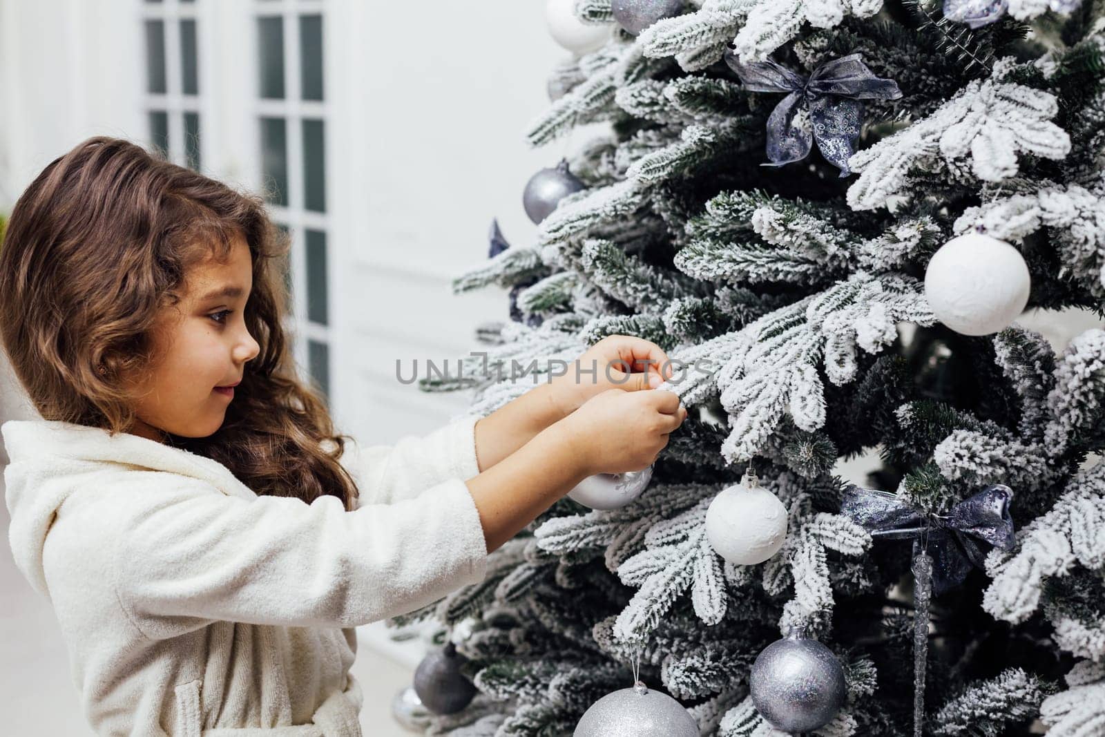 7-year-old girl at christmas tree with gifts and toys