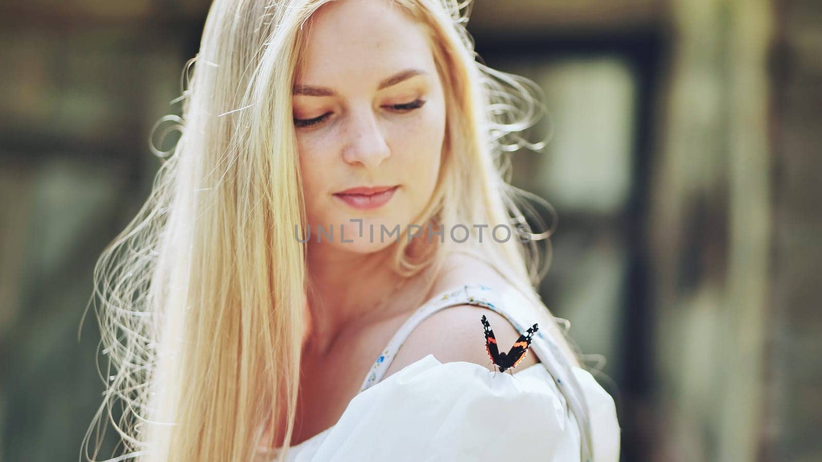 The girl gently enjoys the butterfly that flew to her