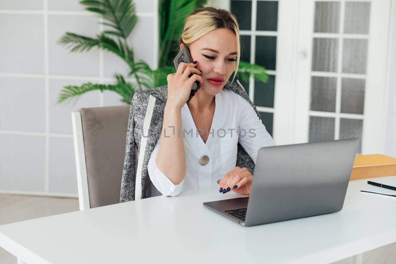 woman talking on the phone in the office at the computer