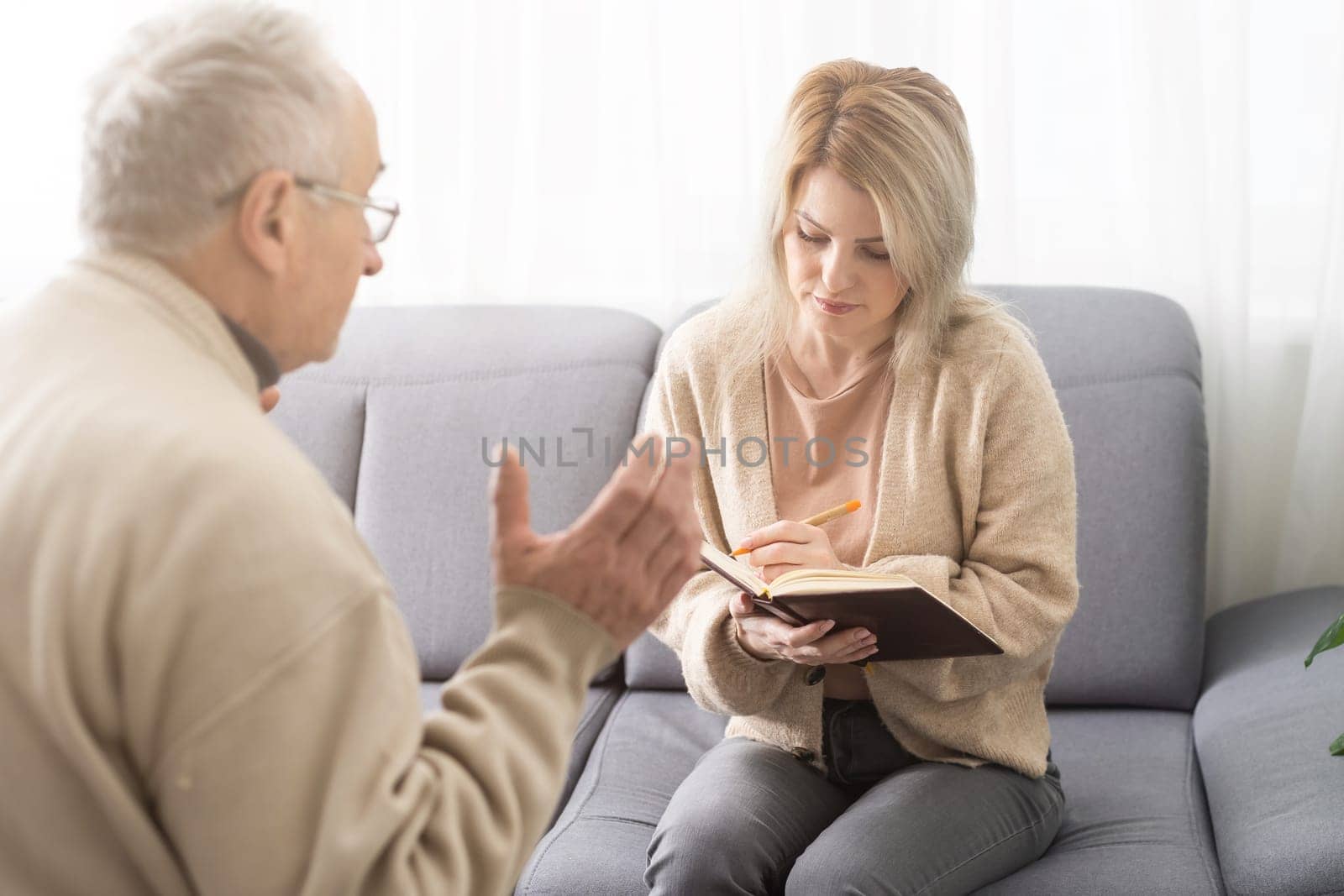 Close up anxious serious old man listening to female doctor at meeting in hospital, therapist physician consulting mature patient about disease, treatment, elderly generation healthcare concept.