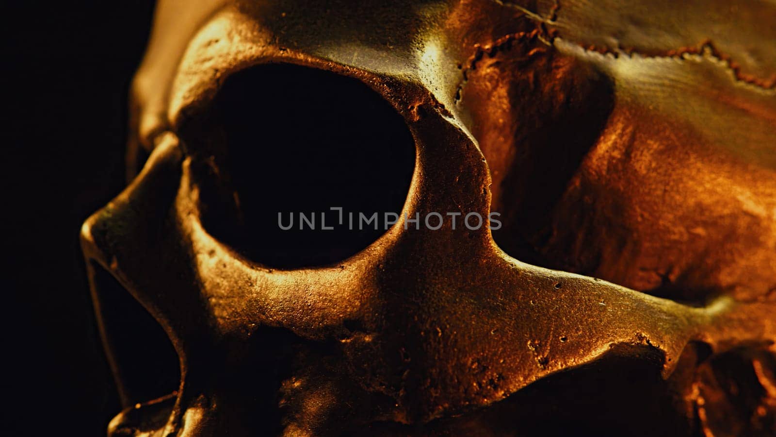 Bronze human skull rotates on black background. Exploring death, gothic theme. by kristina_kokhanova