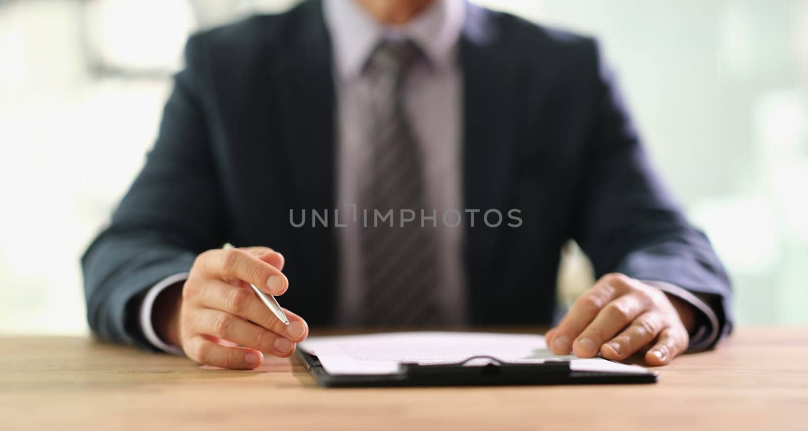 Businessman studying information on document before signing at work in office closeup. Conclusion of contract for employment concept