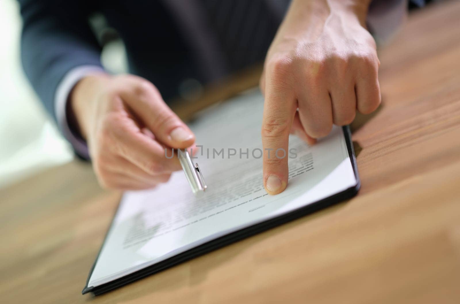 Manager showing client place to sign in document and holding out pen closeup. Legal work with clients and sale of real estate concept