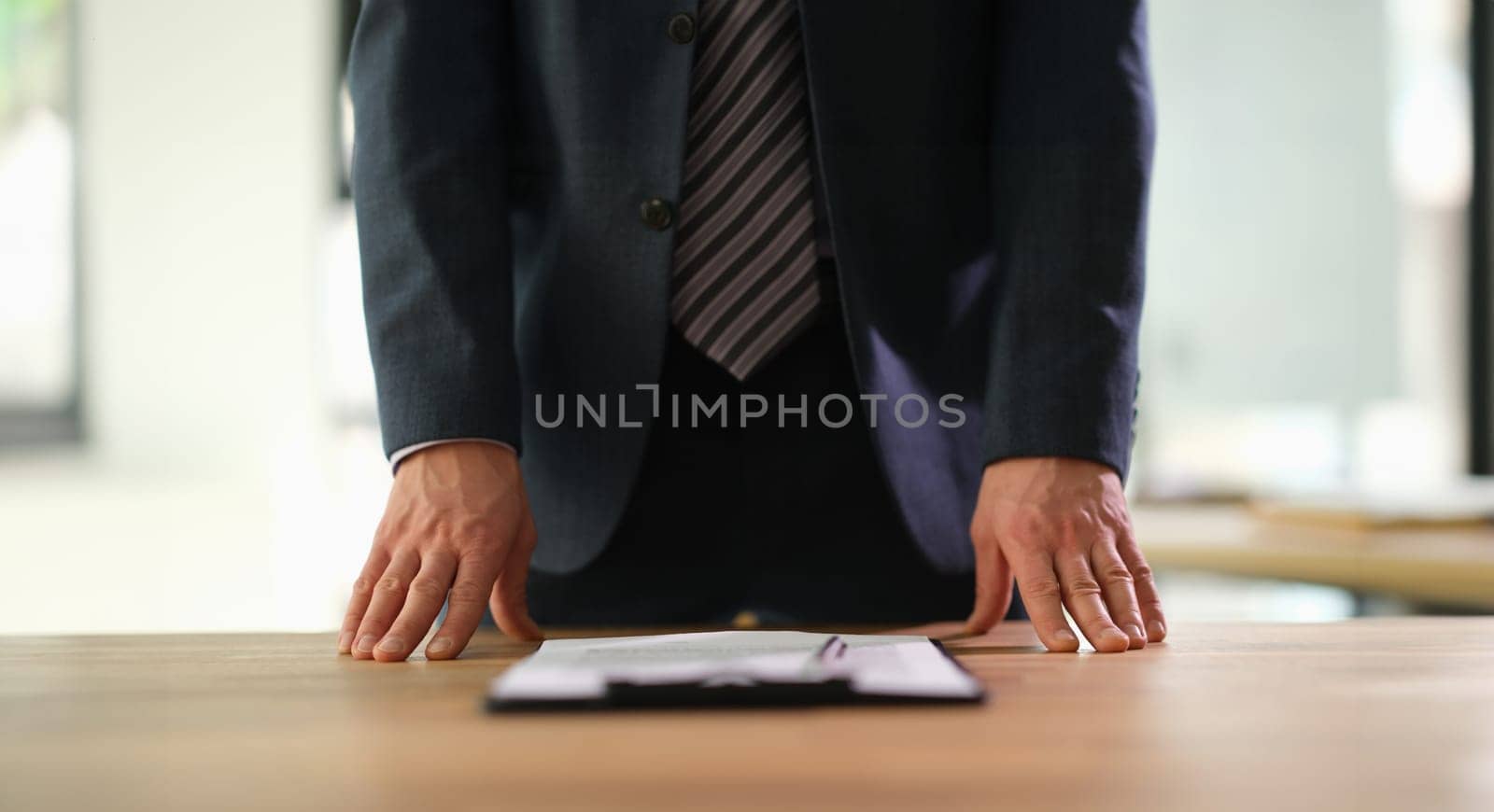 Manager standing at table with documents at business conference closeup by kuprevich
