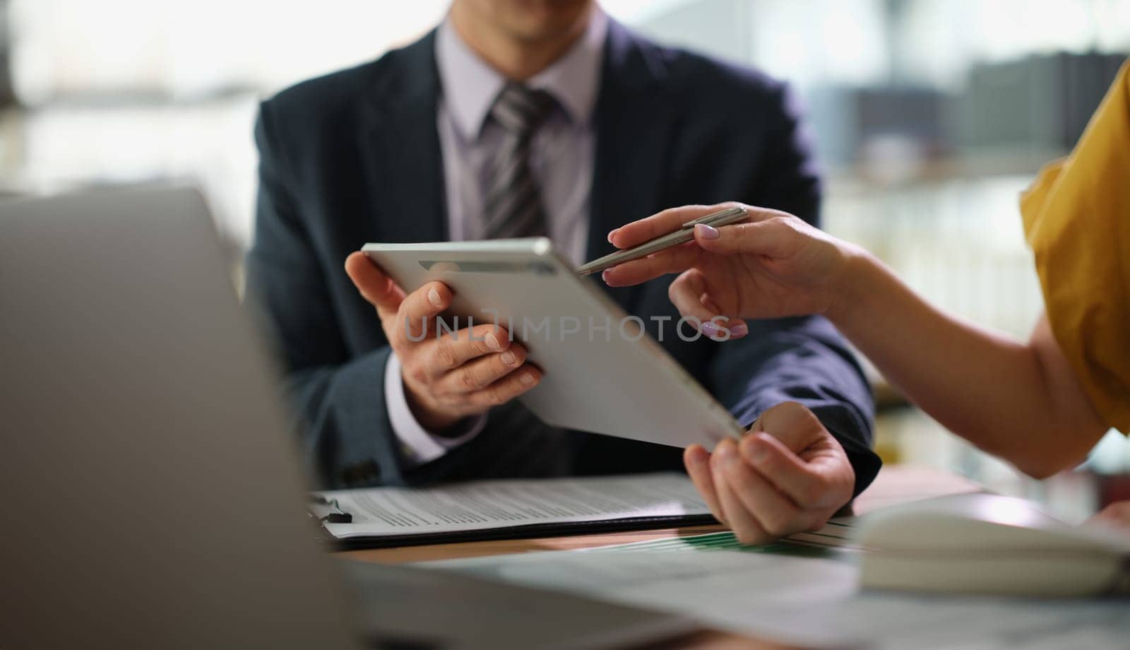 Business partners discussing information on tablet and showing screen with pen closeup. Business strategy marketing concept