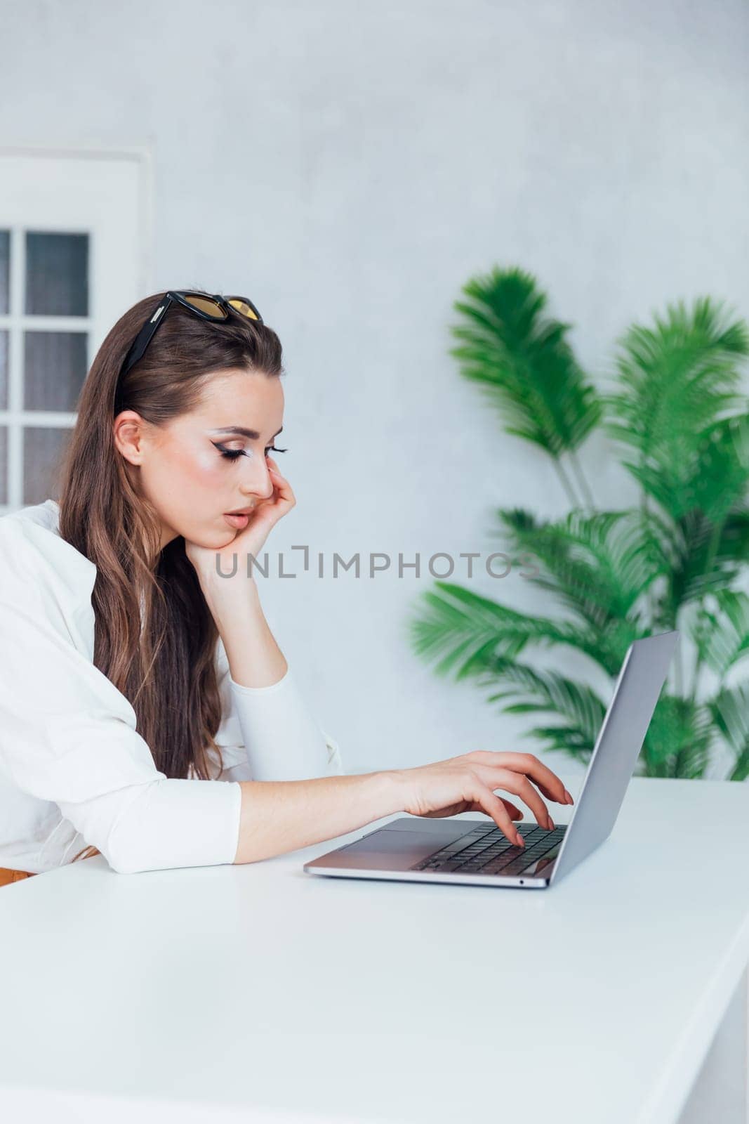 Beautiful woman with laptop learning to work online by Simakov