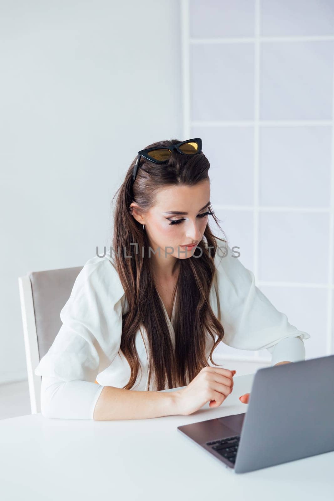 Beautiful woman with laptop learning to work online by Simakov