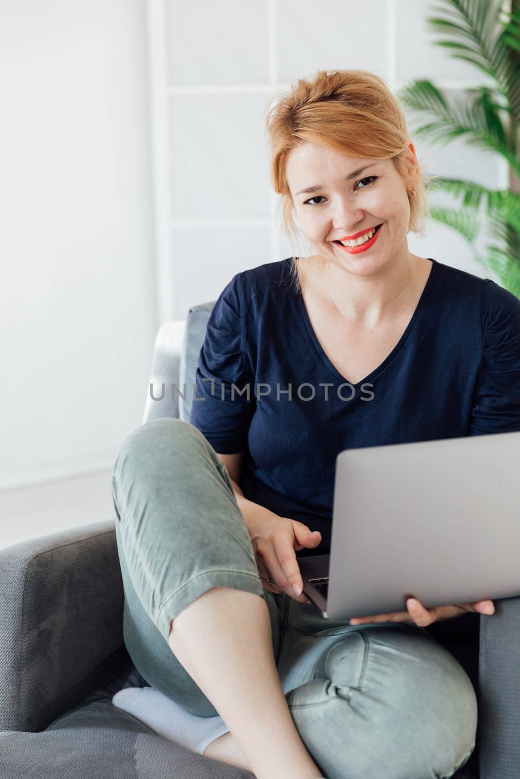 Woman working remotely from home on laptop by Simakov