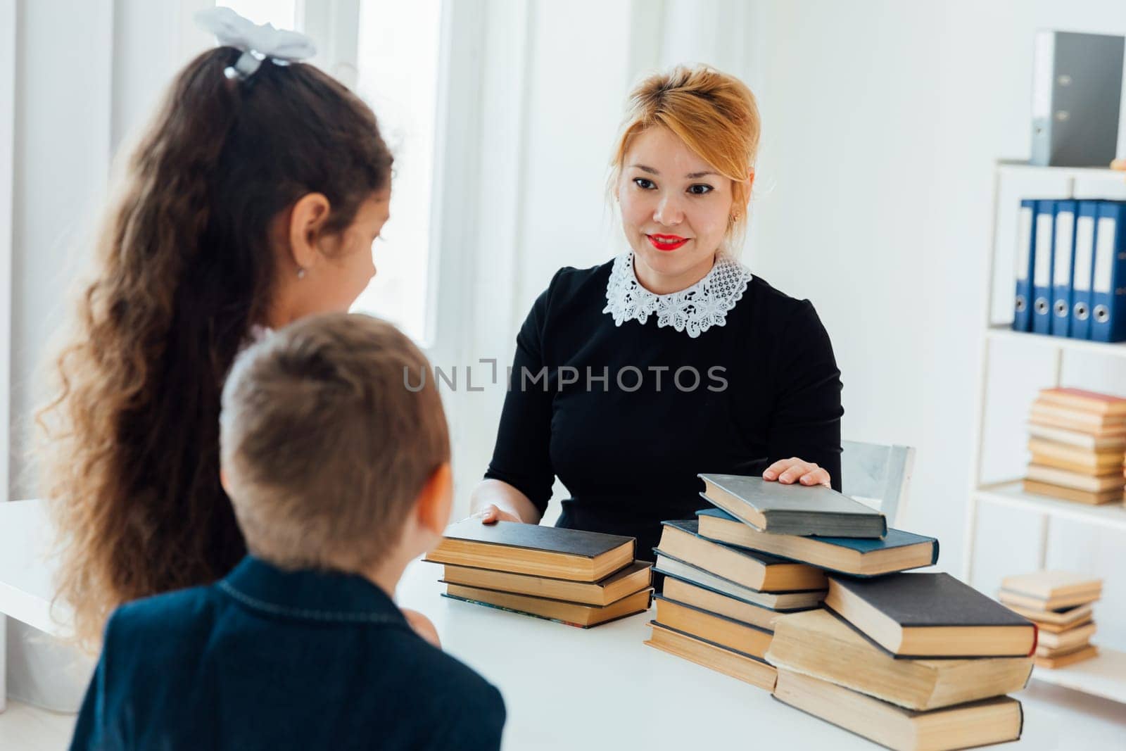 Teacher teaching children at school in lesson by Simakov