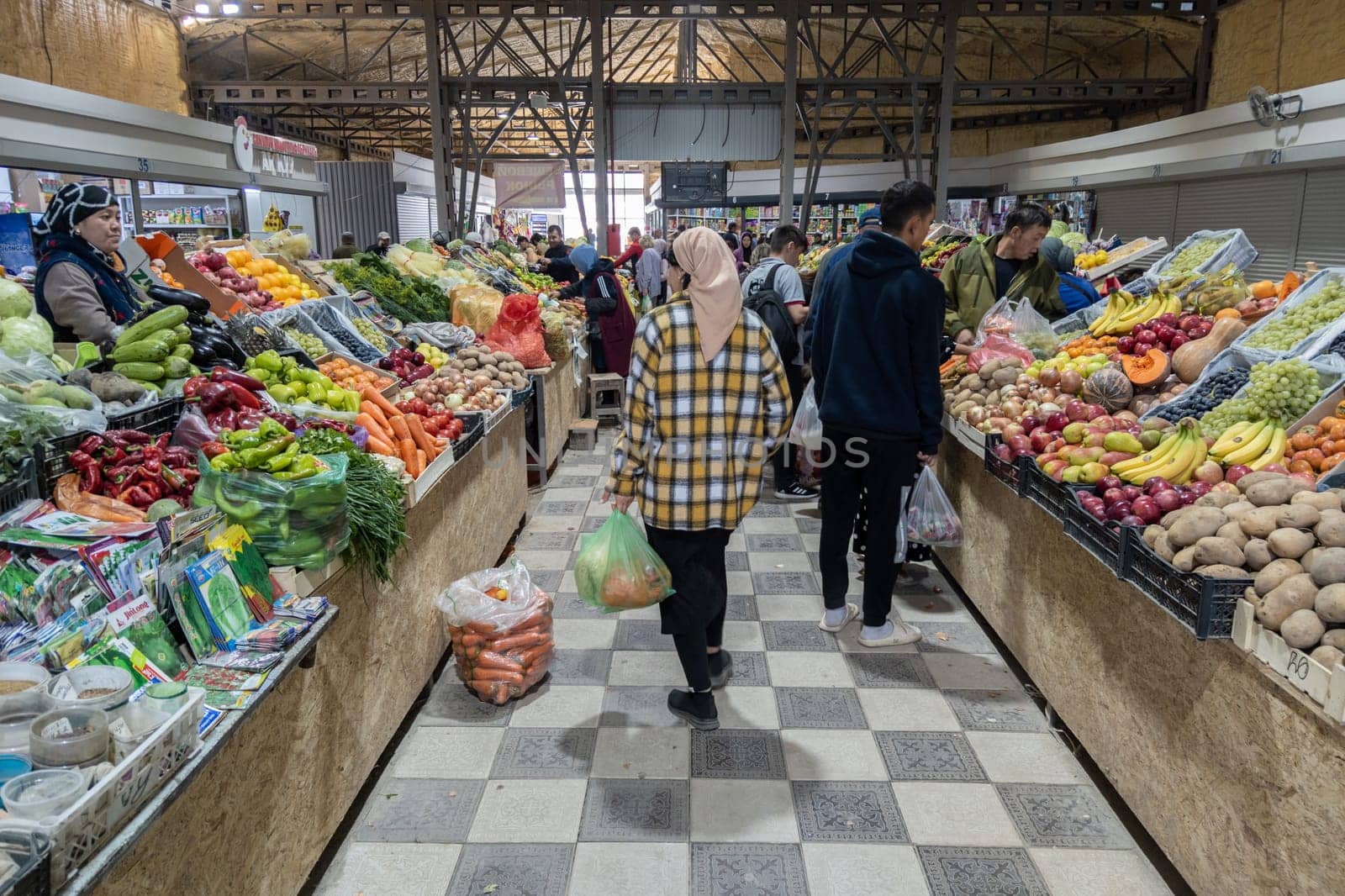 asian food market under roof with fresh vegetables and some clients by z1b