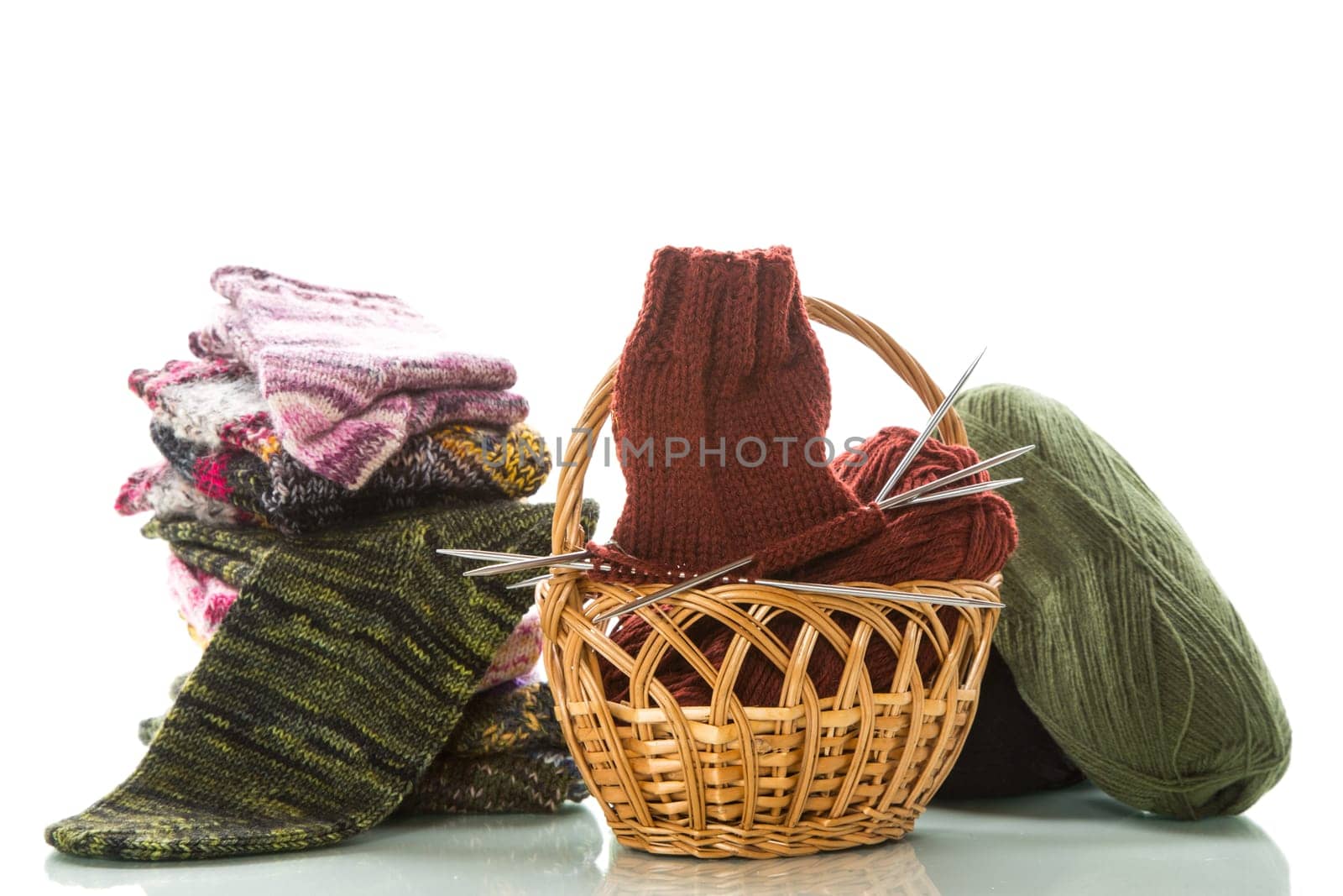 Colored threads, knitting needles and other items for hand knitting, isolated on a white background.