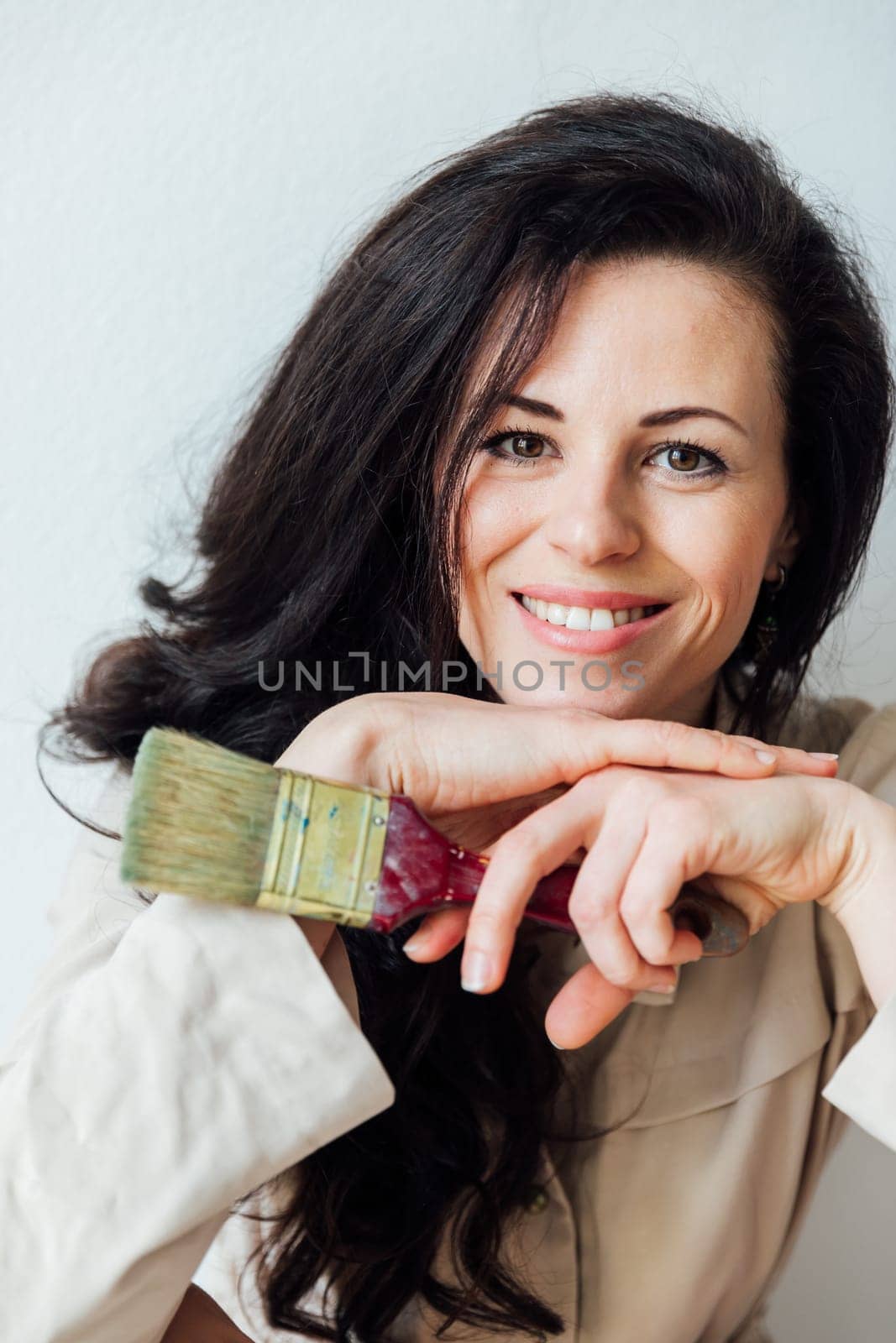 Photo of smiling good mood woman construction worker laughing hold paint brush isolated on yellow color background